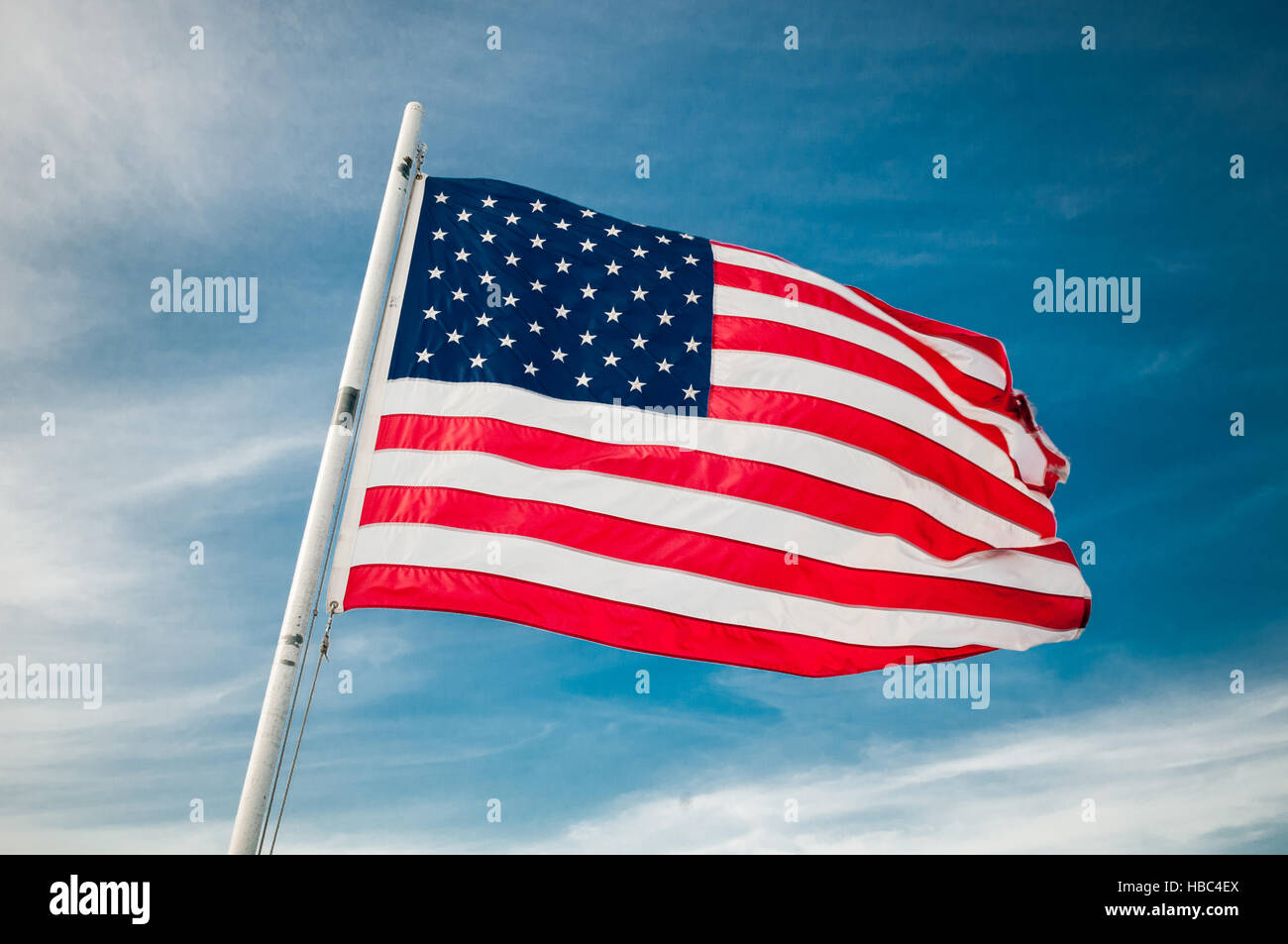 American flag against bright blue sky Stock Photo - Alamy