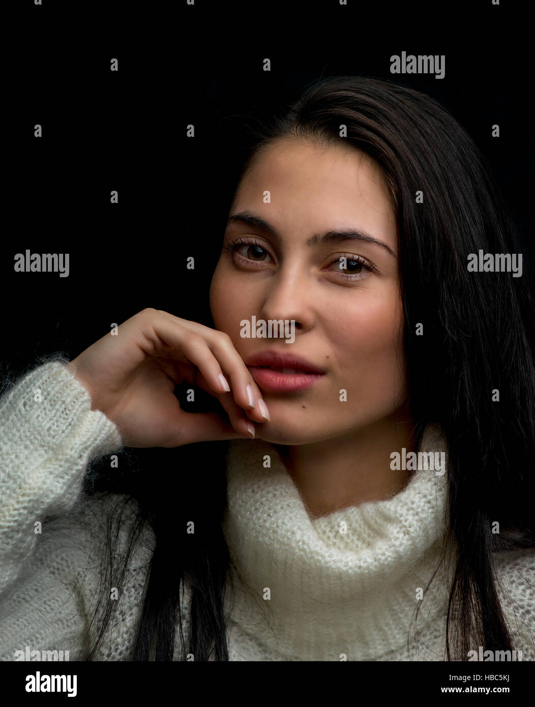 Portrait of young woman lokking at camera on black background Stock Photo