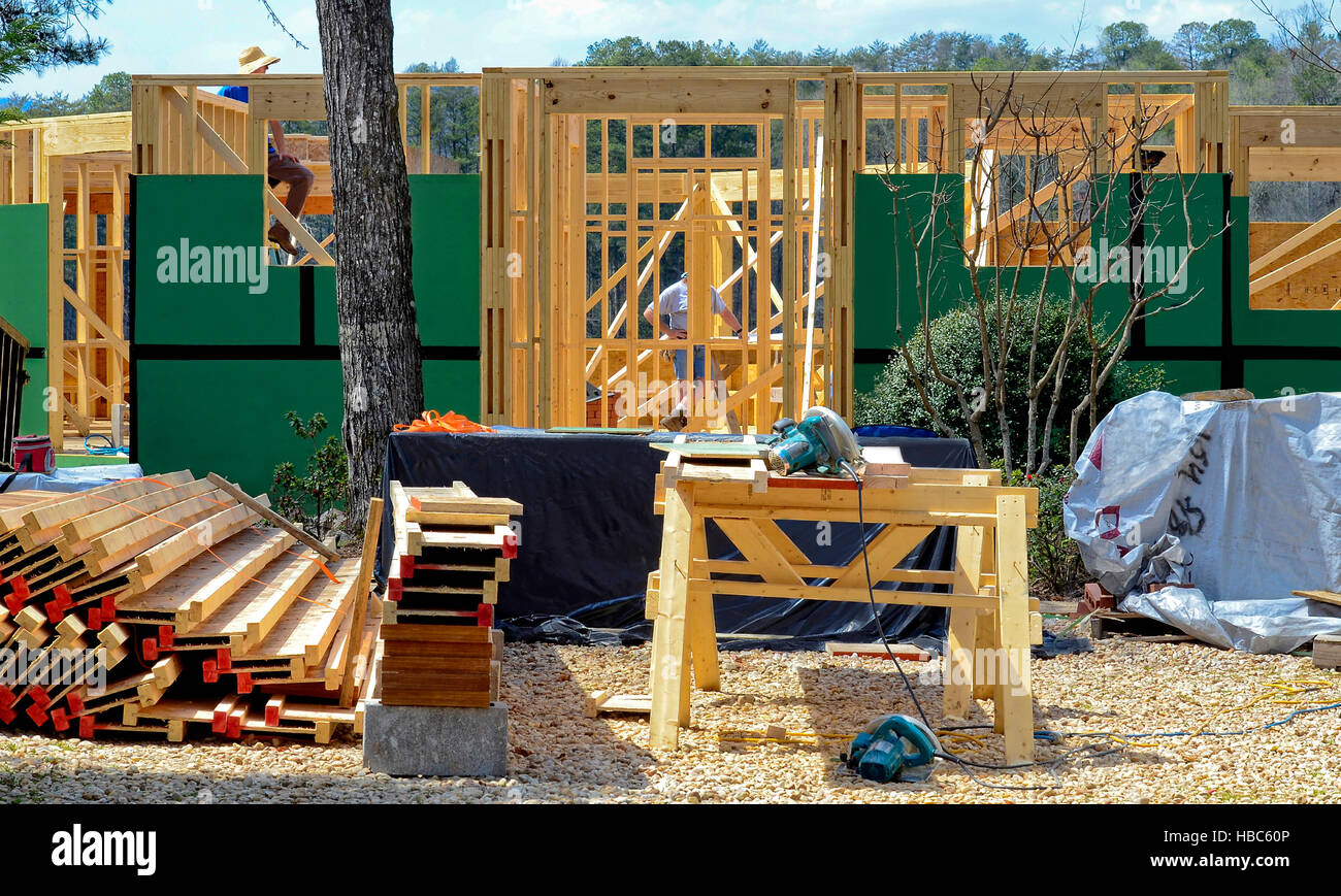 A new house being built.  Lumber, tools and workers are on site. Stock Photo