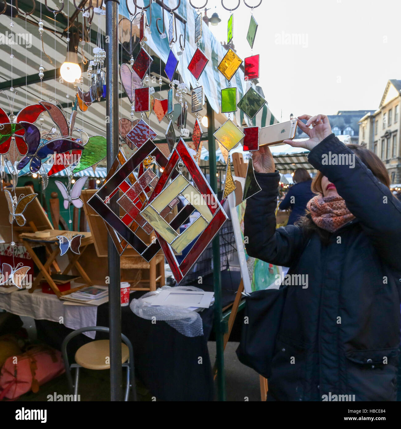 Broad Street, Oxford, United Kingdom, December 04, 2016: Arts and Crafts Market with open stalls on Broad Street stall with stained glass art christmas pendants, Oxford. Stock Photo