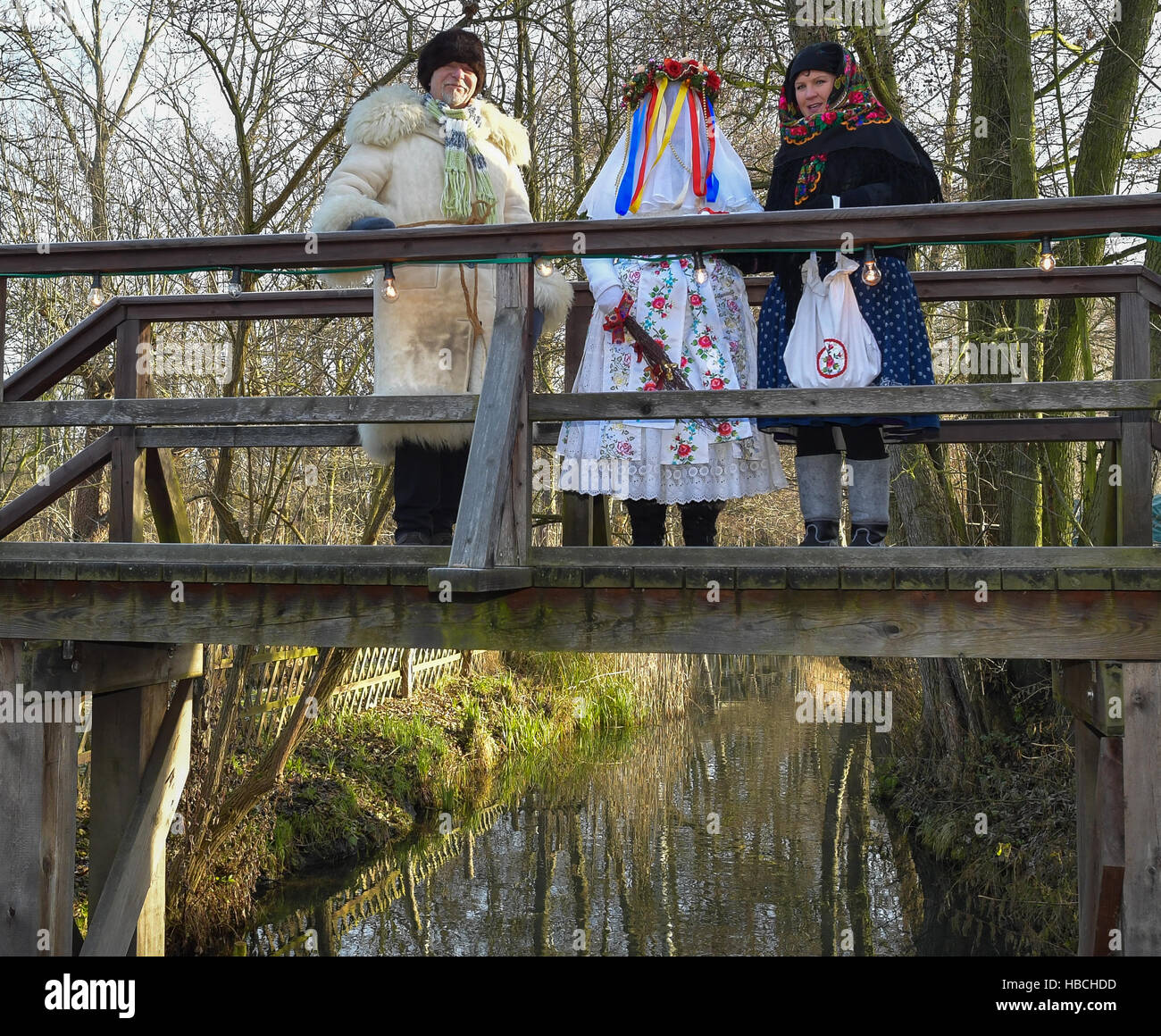 Lehde, Germany. 3rd Dec, 2016. The so-called Bescherkind (c), following an old pre-Christmas Lusatian custom, with its companion, and Rumpodich, the Knecht Ruprecht (approx. Santa's little helper) of the Spreewald region, pictured on a bridge over a stream at the Freilandmuseum in the Spreewald village of Lehde, Germany, 3 December 2016. Visitors can visit the Christmas Market by barge and learn about the customs and traditions of the Spreewald's inhabitants. Photo: Patrick Pleul/dpa-Zentralbild/ZB/dpa/Alamy Live News Stock Photo