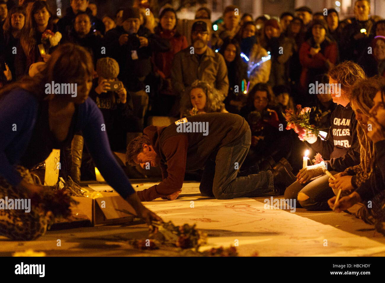 Oakland, USA. 05th Dec, 2016. A man is overcome by emotion as he writes out a message during a candle light vigil for victims of the Ghost Ship fire in Oakland, CA. Credit:  John Orvis/Alamy Live News Stock Photo