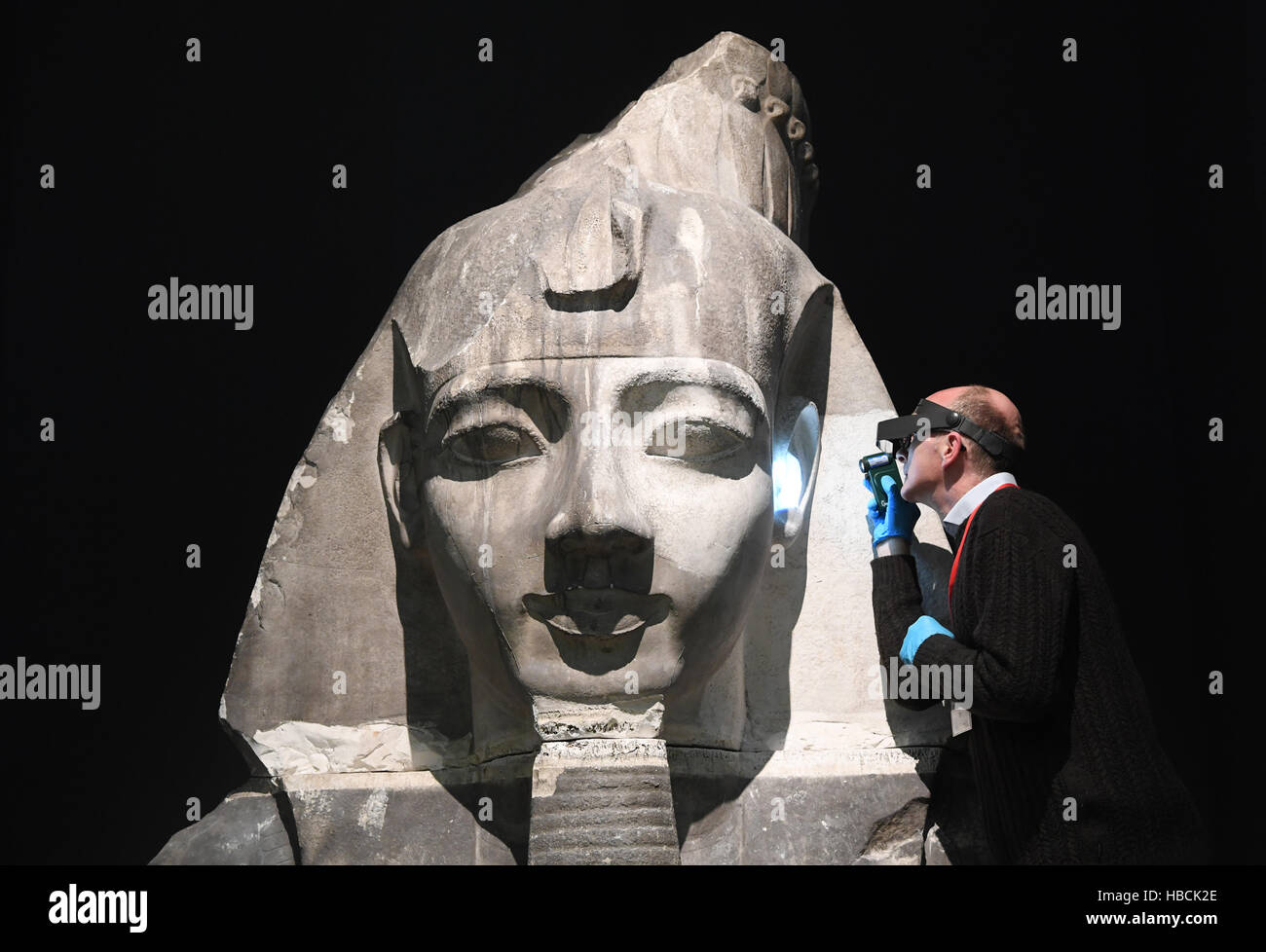 Oliver Morr, head of restorations at the Badischen Landesmuseum, works on a 3.metre-high bust of Ramses II made out of plaster in the Karlsruhe Castle in Germany, 06 December 2016. The bust, made in London in 1873, will be displayed as part of the museum's 'Ramses: Divine Ruler on the Nile' exhibition that opens on the 17.12.2016 and runs through to the 18.06.2017. Photo: Uli Deck/dpa Stock Photo