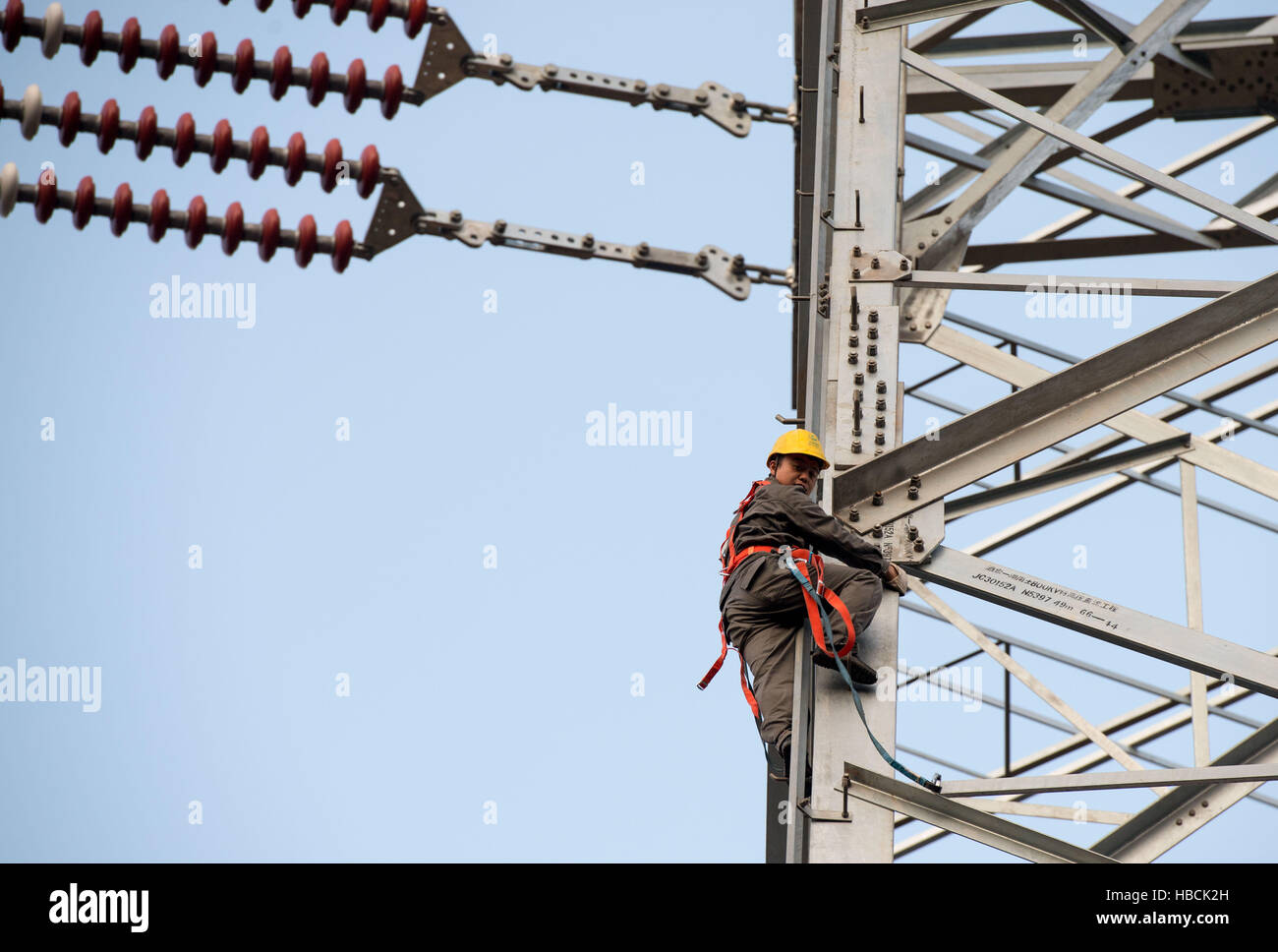 Chongqing. 6th Dec, 2016. A technician inspects the tower of the ¡À800KV Ultra High Voltage (UHV) transmission line in Wushan County of southwest China's Chongqing, Dec. 6, 2016. The ¡À800KV UHV transmission line will run 2,383 meters from Jiuquan in northwest China's Gansu Province to Xiangtan in central China's Hunan Province. It's so far the longest transmission line of its kind in China. © Liu Chan/Xinhua/Alamy Live News Stock Photo