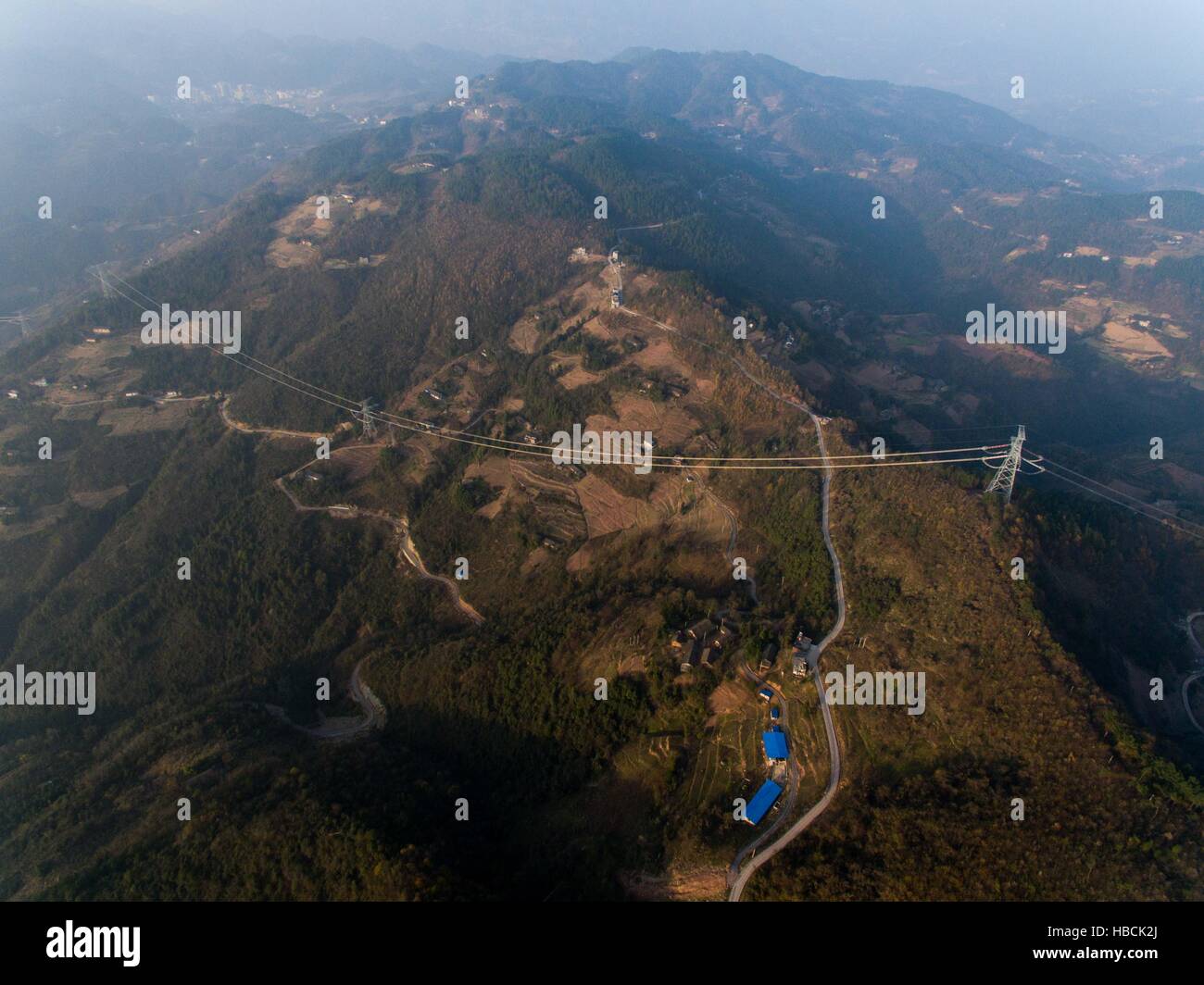 Chongqing. 6th Dec, 2016. Photo taken on Dec. 6, 2016 shows the ¡À800KV Ultra High Voltage (UHV) transmission line in Wushan County of southwest China's Chongqing. The ¡À800KV UHV transmission line will run 2,383 meters from Jiuquan in northwest China's Gansu Province to Xiangtan in central China's Hunan Province. It's so far the longest transmission line of its kind in China. © Liu Chan/Xinhua/Alamy Live News Stock Photo