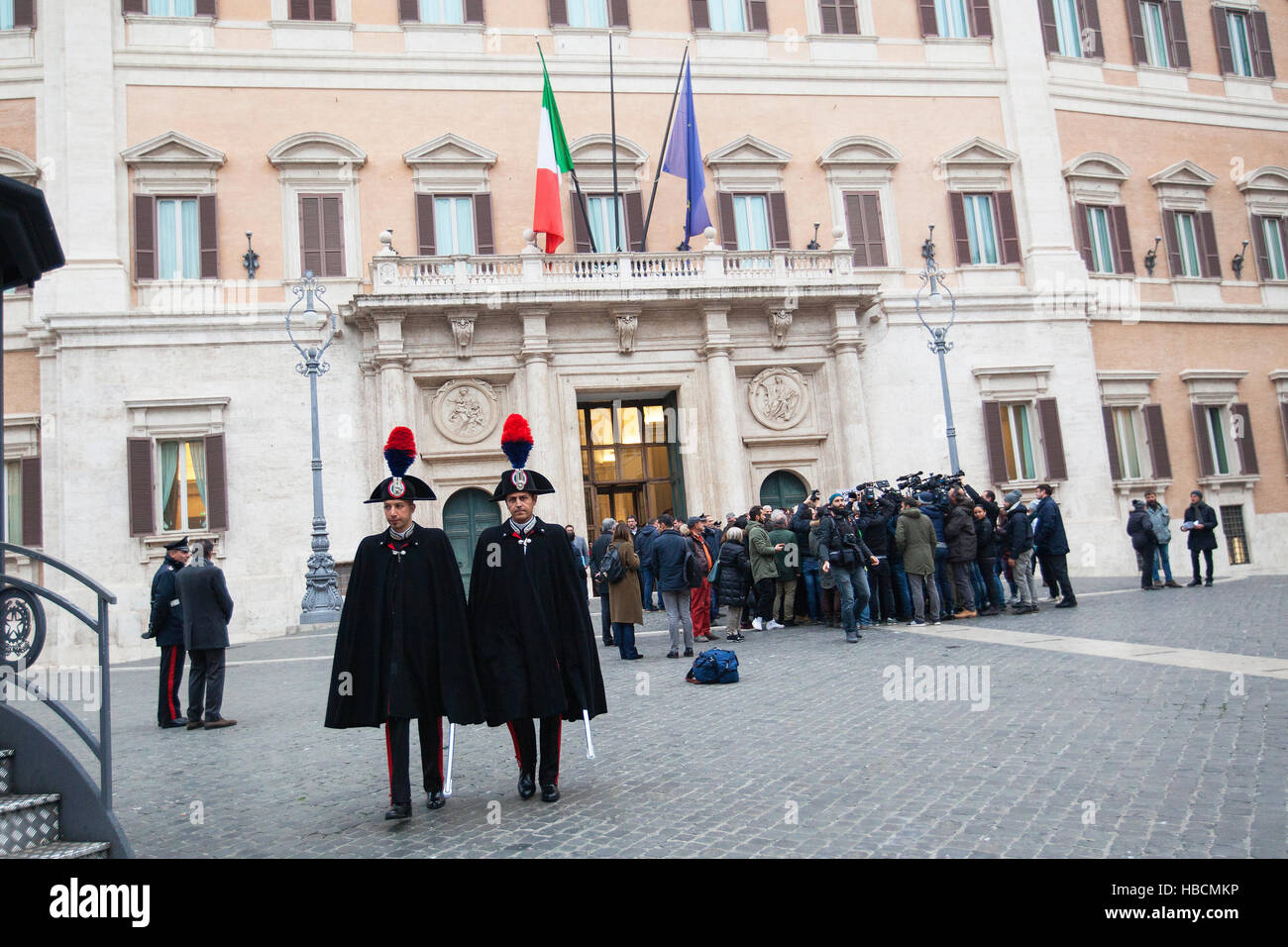 Rome, Italy. 6th December 2016. Two Italian Carabinieri walk past a flash mob lead by Matteo Salvini, head of Italy's Northern League, outside Palazzo Montecitorio in Rome, Italy. Credit:  Sara De Marco/Alamy Live News Stock Photo