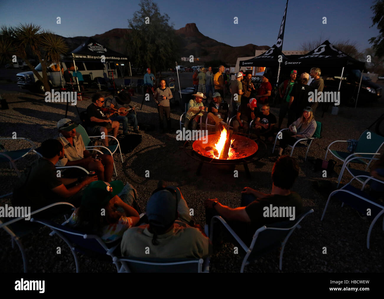 Mountain bikers sit around the fire at the Big Chihuahua Desert Challenge in Lajitas, Texas. Stock Photo