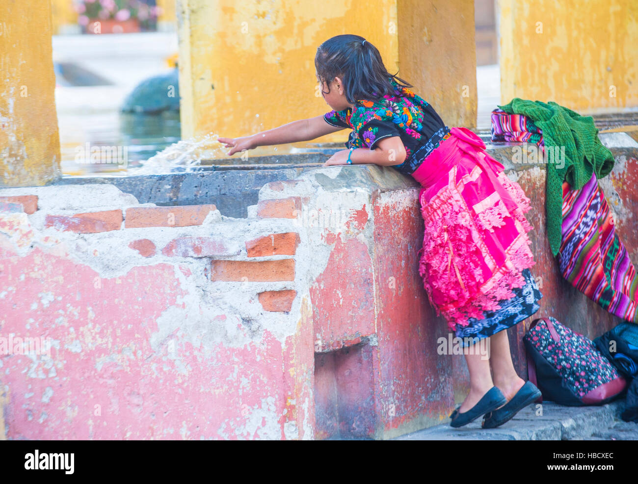 Guatemalan girl wash laundry in a traditional street washing facility in Antigua, Guatemala Stock Photo