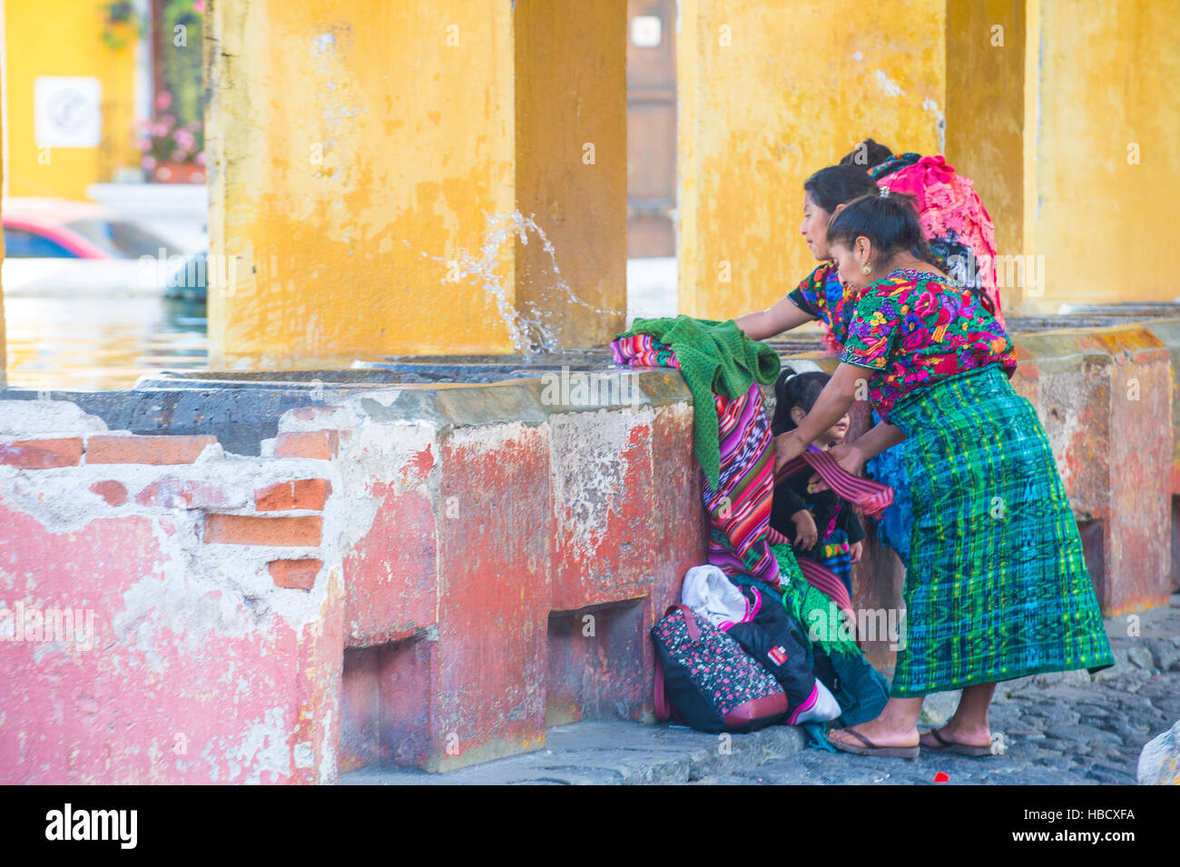 Guatemalan women wash laundry in a traditional street washing facility in Antigua, Guatemala Stock Photo