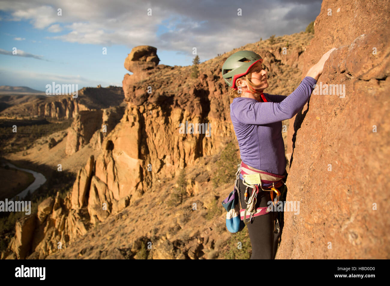 Female rock climber climbing mountain, Smith Rock State Park, Oregon, USA Stock Photo