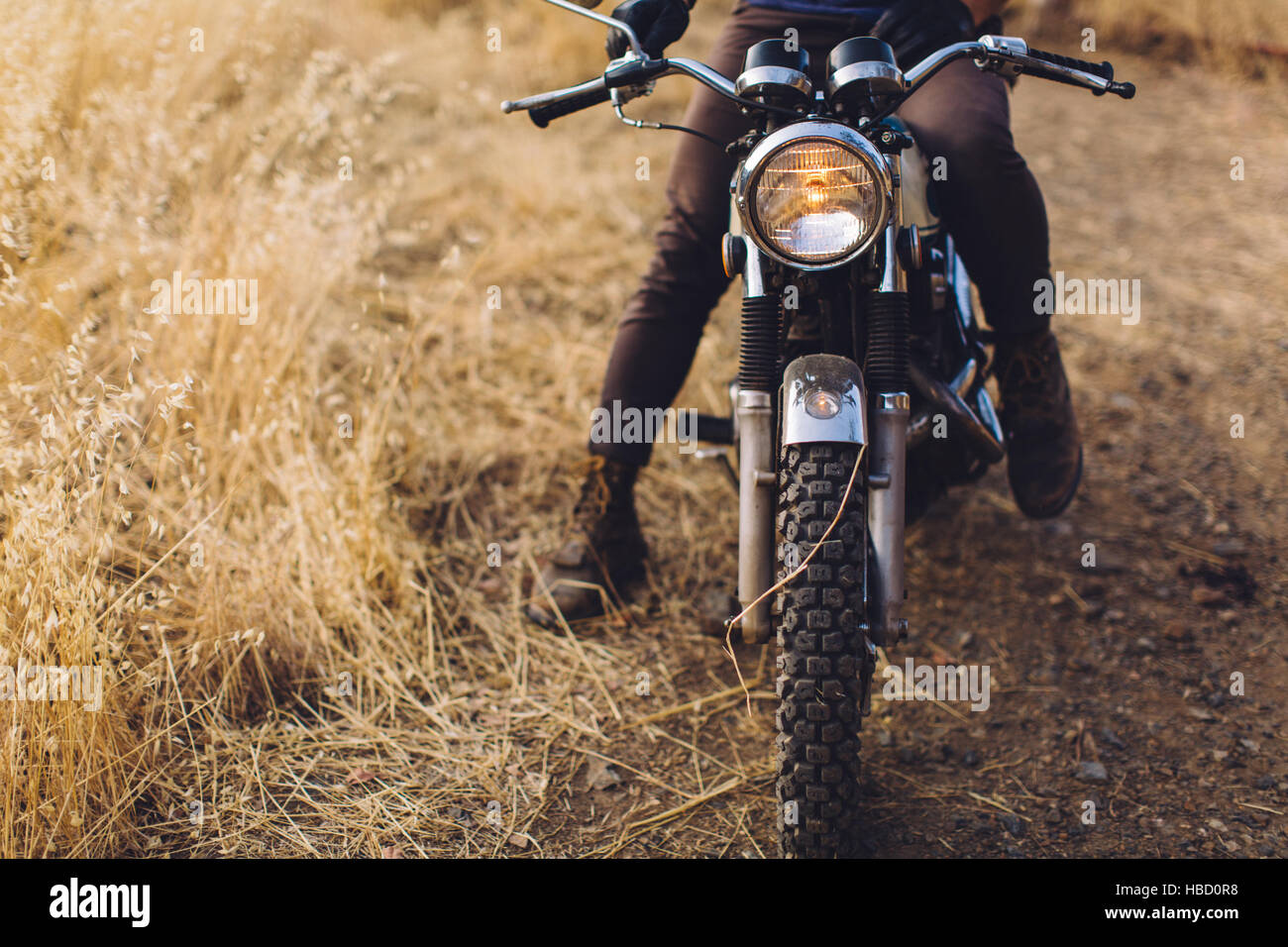 Man sitting on motorbike, low section Stock Photo