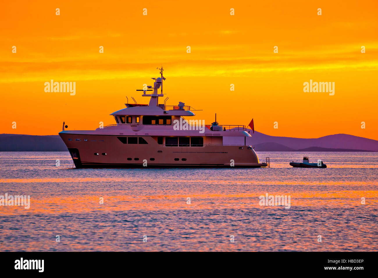 Yacht at golden sunset on open sea Stock Photo