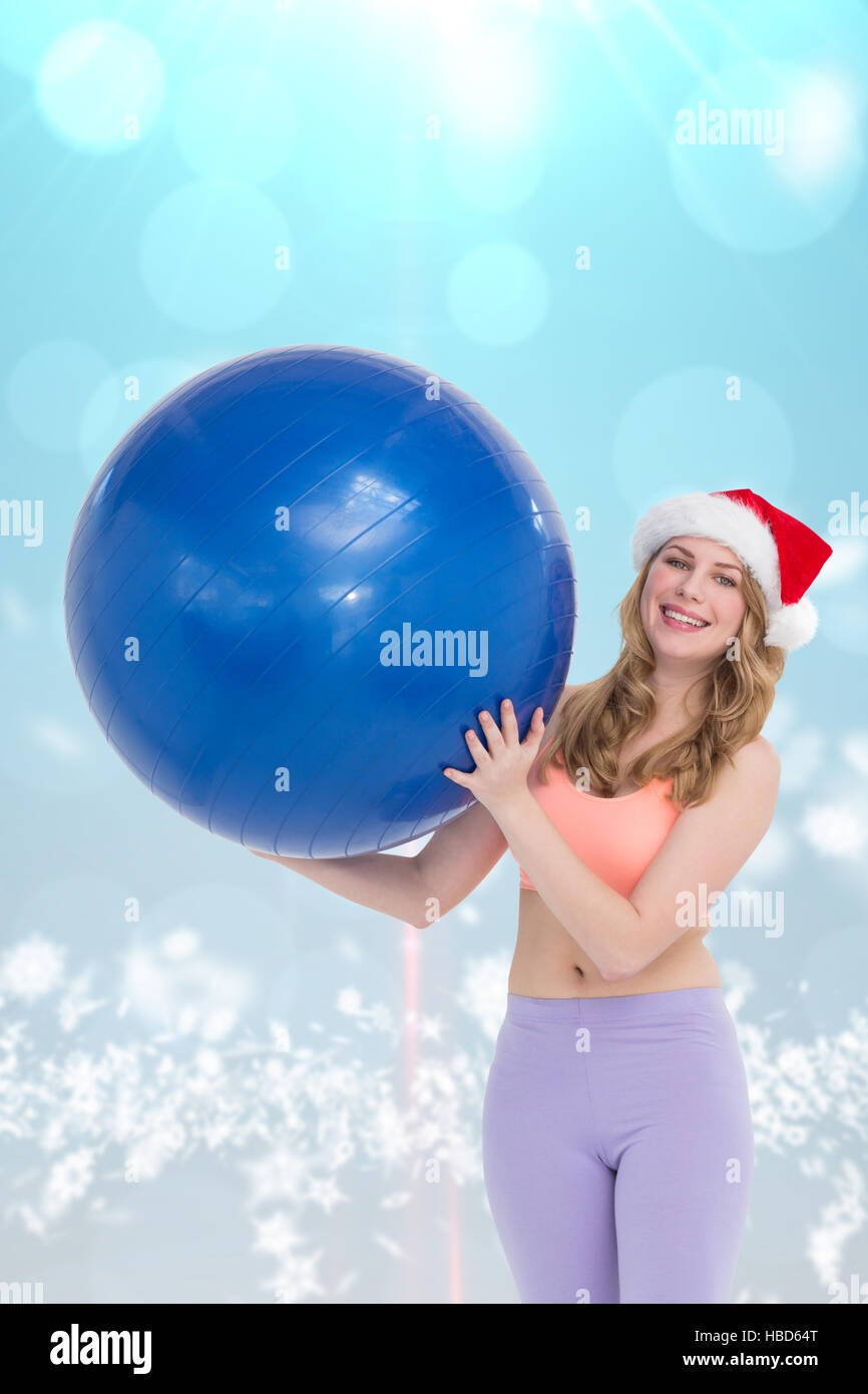 Composite image of smiling blonde woman holding exercise ball Stock Photo