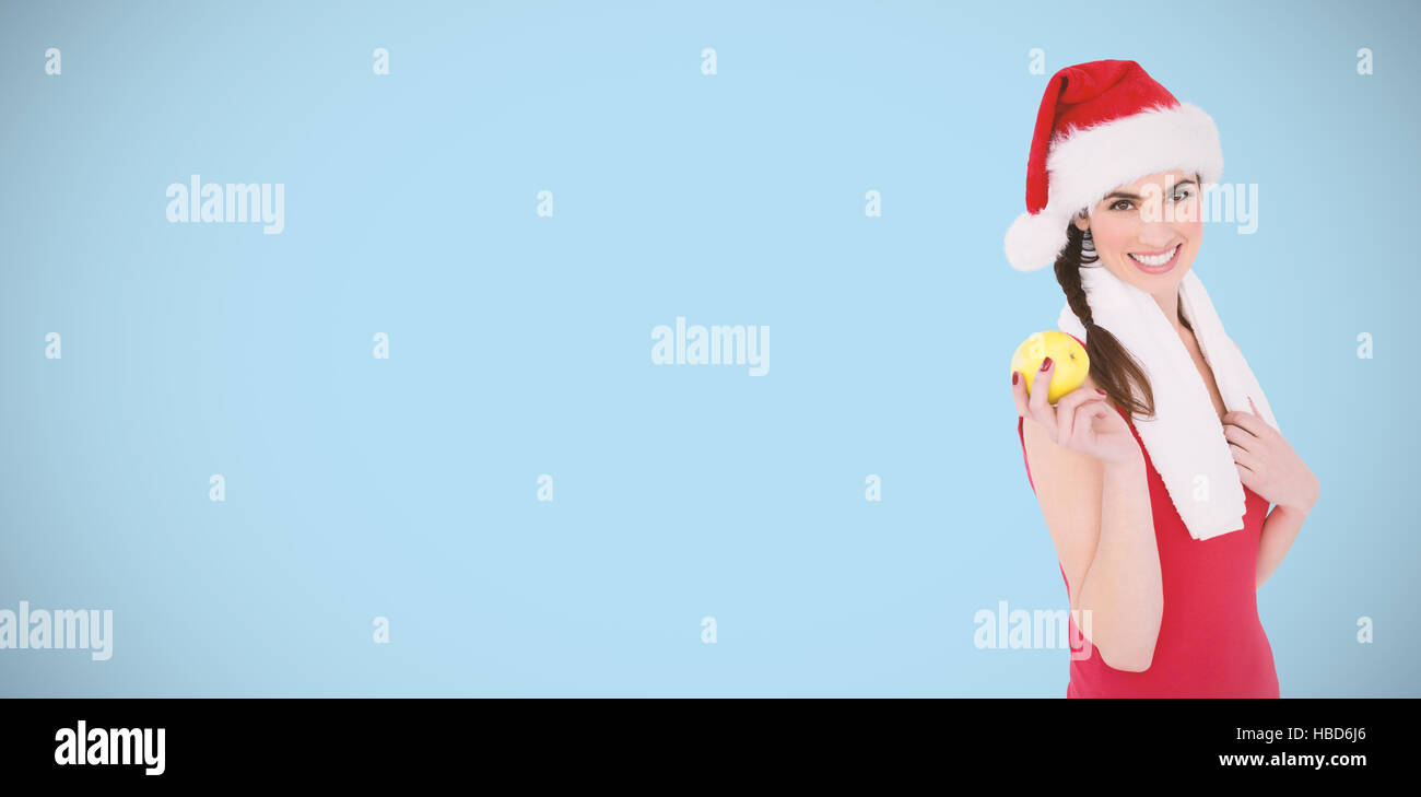 Composite image of festive fit brunette holding apple Stock Photo