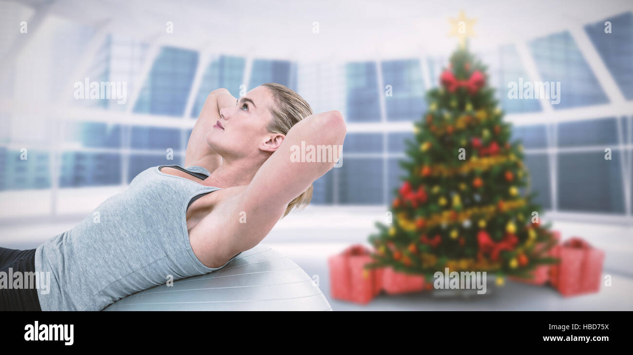 Composite image of muscular woman doing sit ups on exercise ball Stock Photo