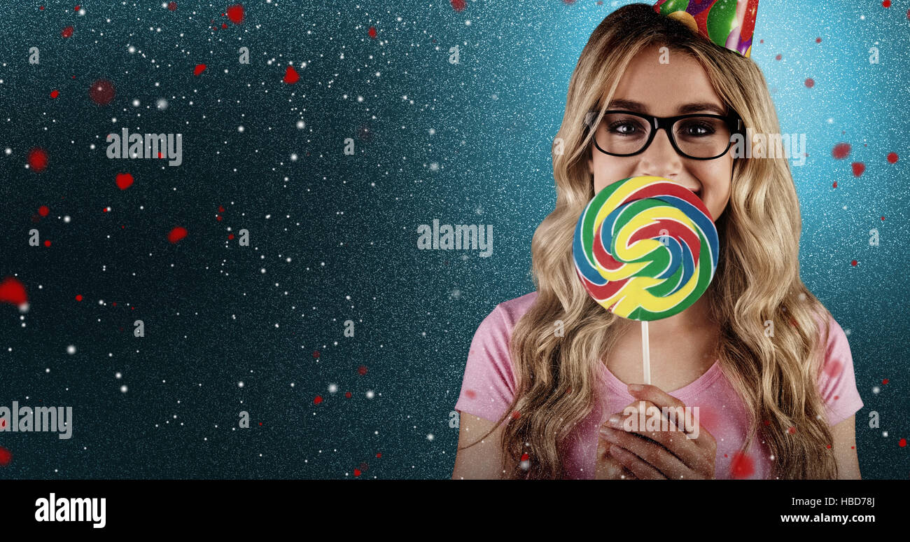 Composite image of a beautiful hipster holding a giant lollipop Stock Photo