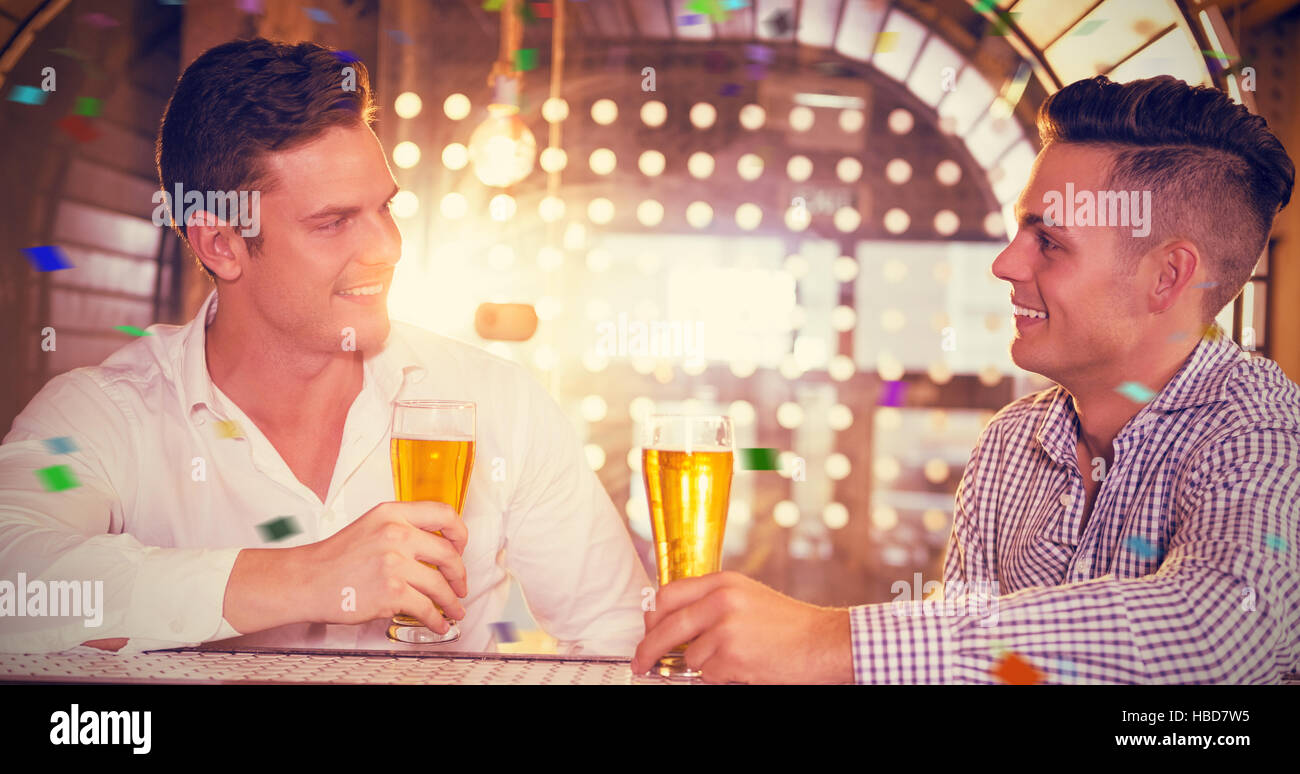 Composite image of two men having glass of beer Stock Photo