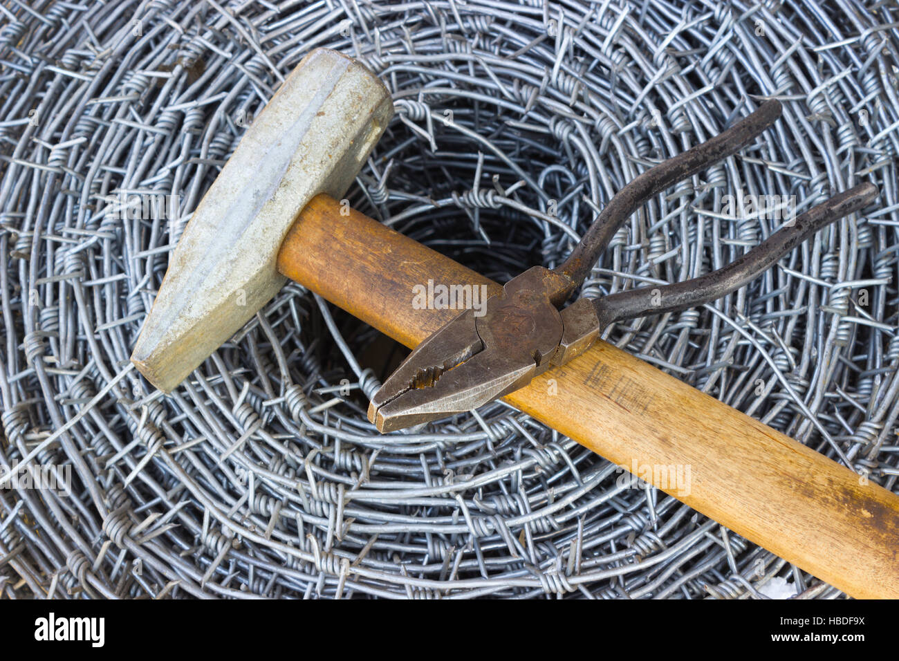 Barbed wire, a hammer and pliers Stock Photo