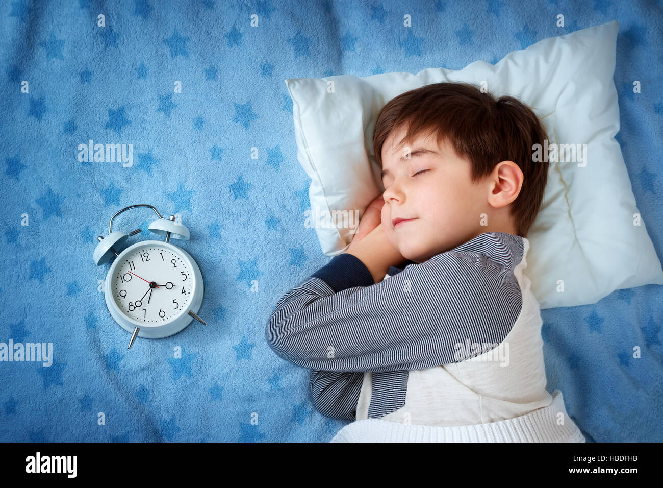 six years old child sleeping in bed with alarm clock Stock Photo Alamy