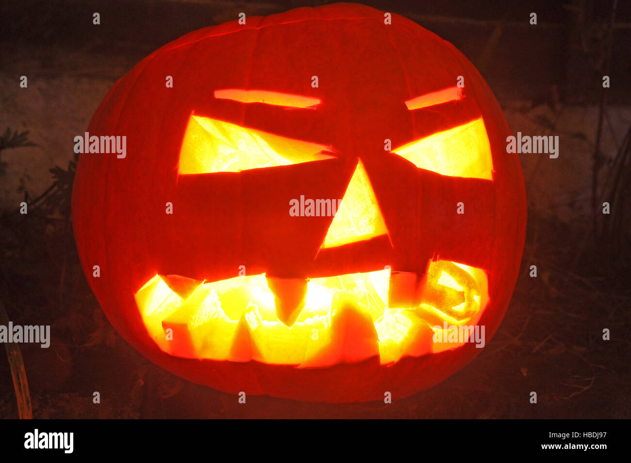 Halloween Pumpkin, lit up, with baby pumpkin in jaws Stock Photo
