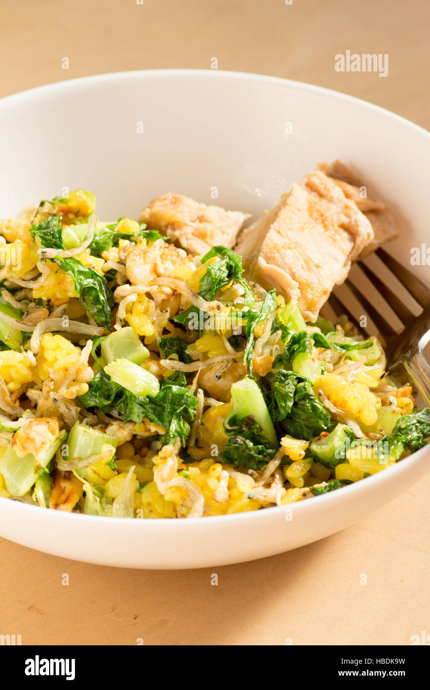 Japanese cuisine, fish and egg fried rice with grilled chicken in a white bowl Stock Photo