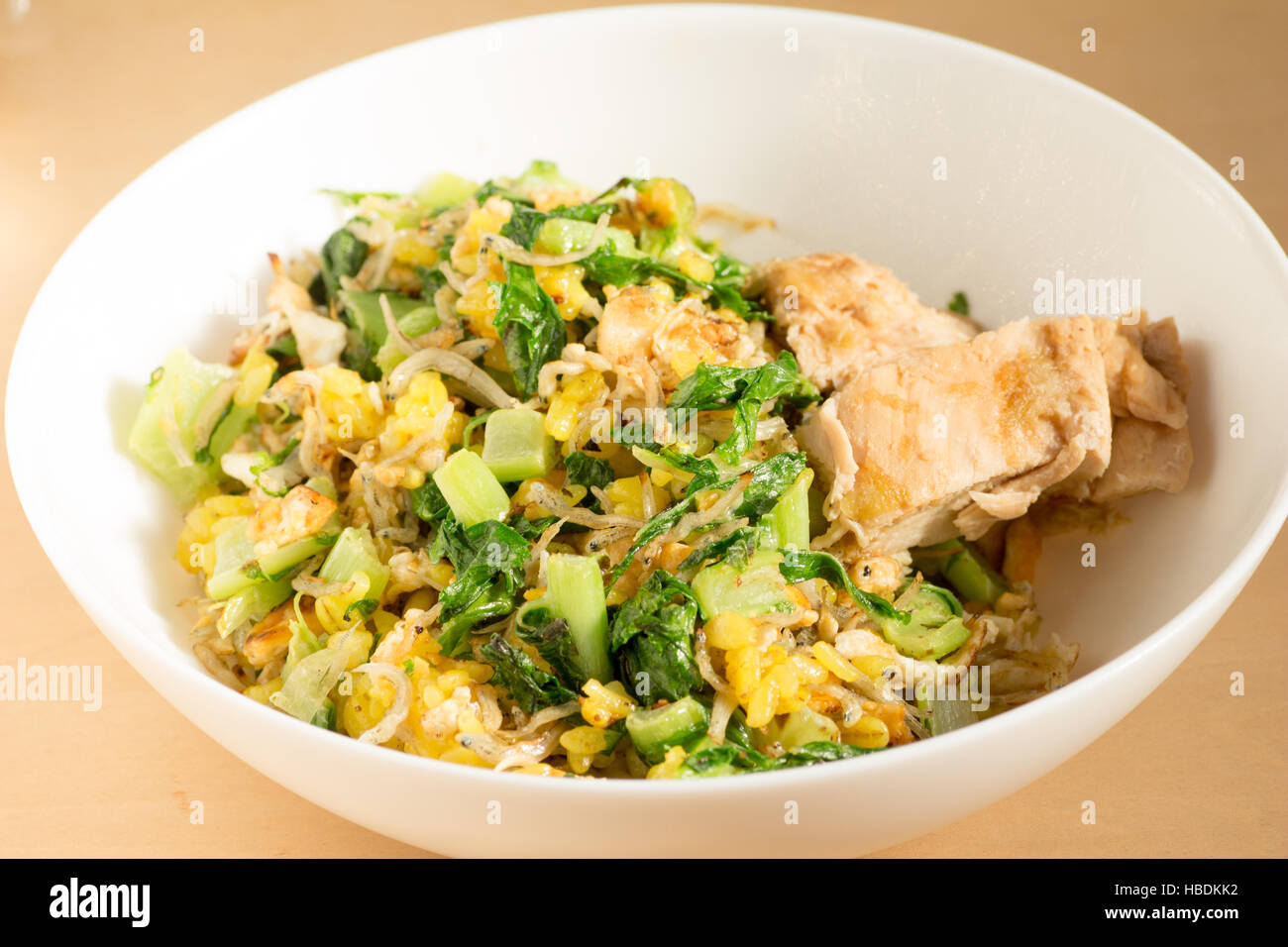 Japanese cuisine, fish and egg fried rice with grilled chicken in a white bowl Stock Photo