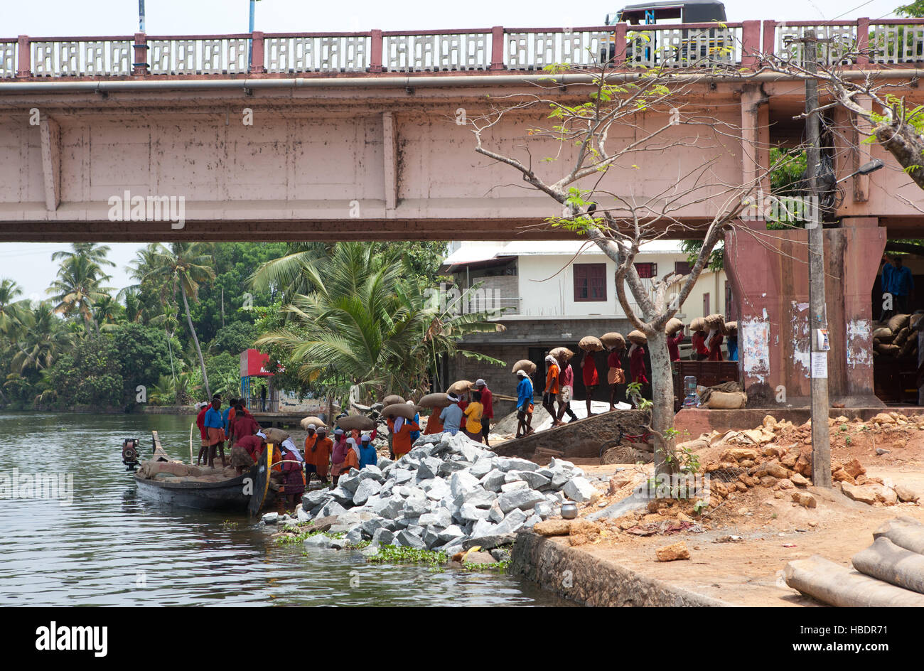 Workers unloading rice barge under a bridge  in Alappuzha (Alleppey), Kerala, India, Stock Photo
