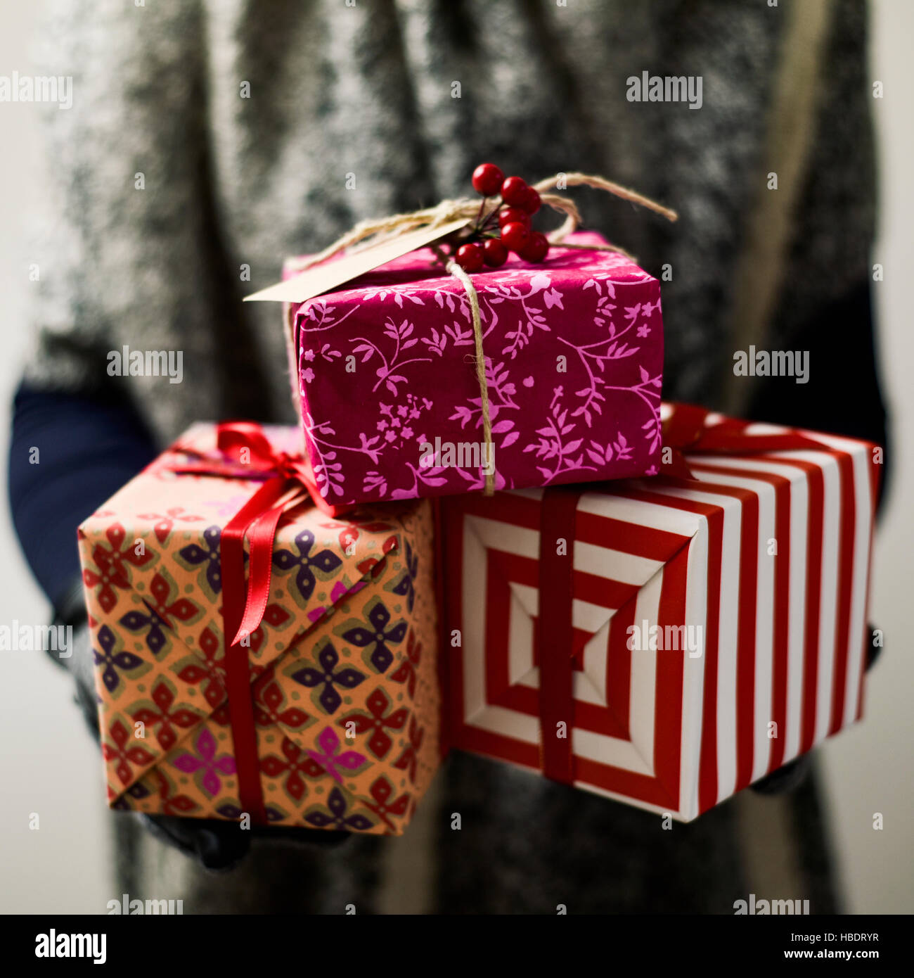 closeup of a young caucasian woman holding a pile of cozy christmas gifts in her hands Stock Photo