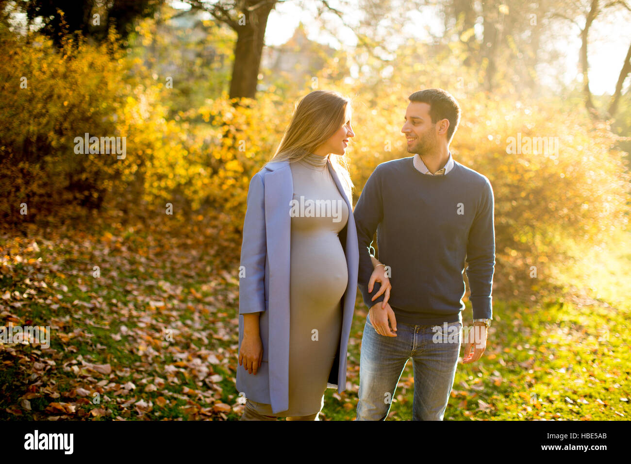 Pregnant woman and man posing at autumn park Stock Photo - Alamy