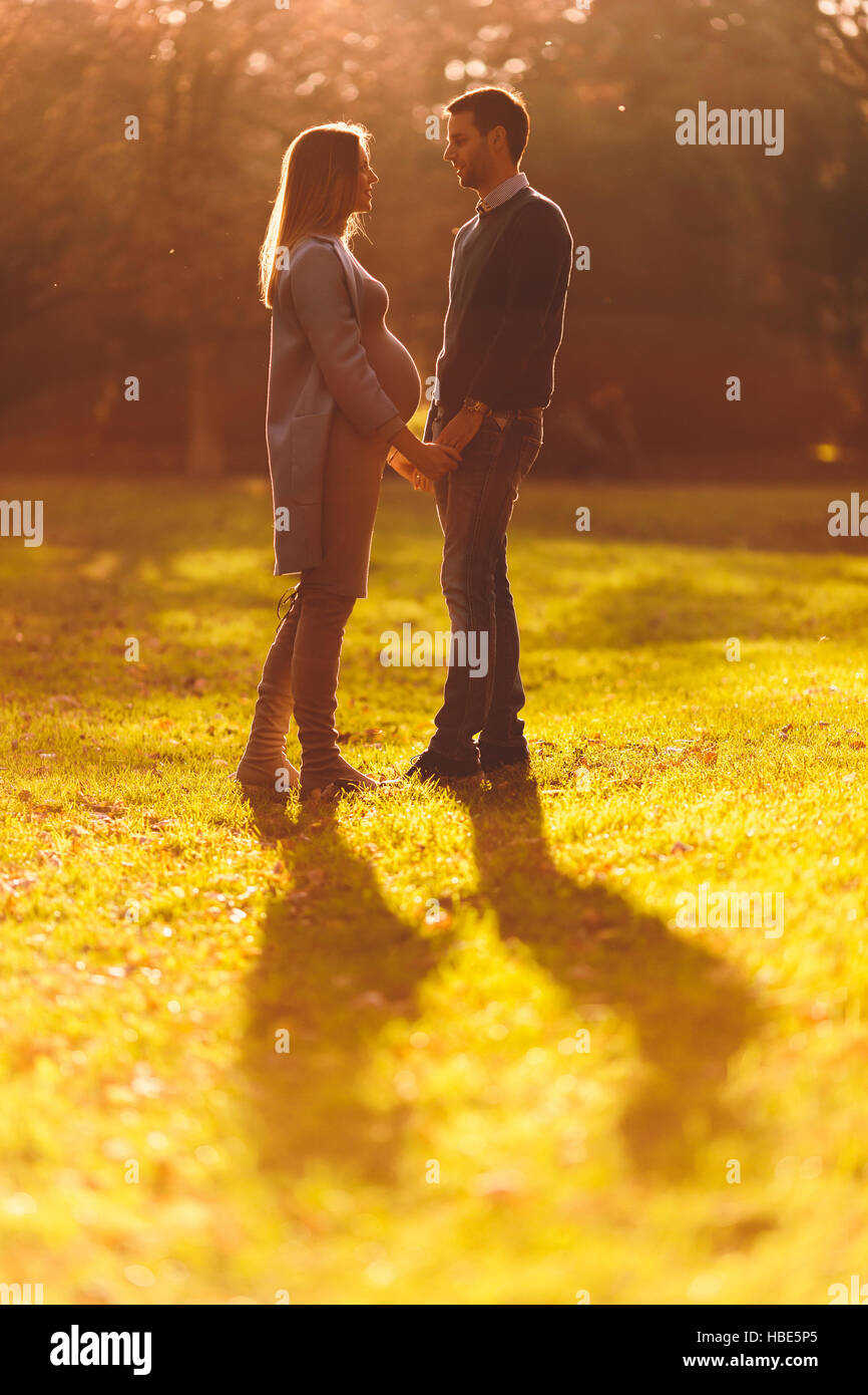 Pregnant woman and man posing at autumn park Stock Photo - Alamy