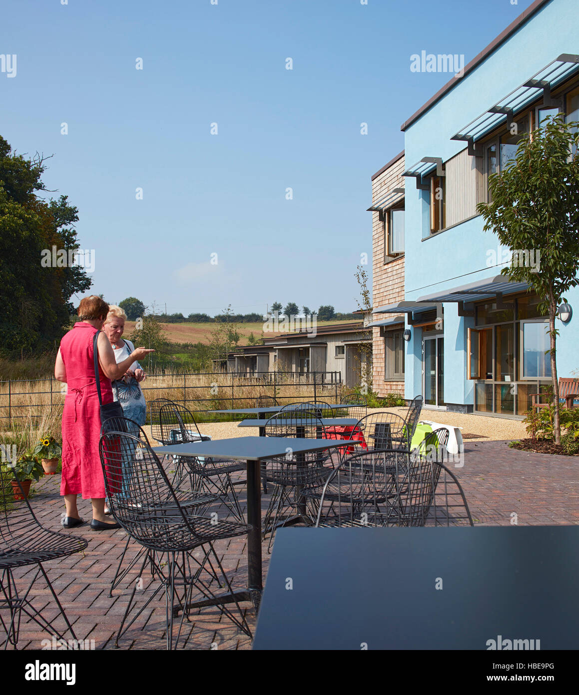 Landscaped hospice garden and terrace with visitors and view to