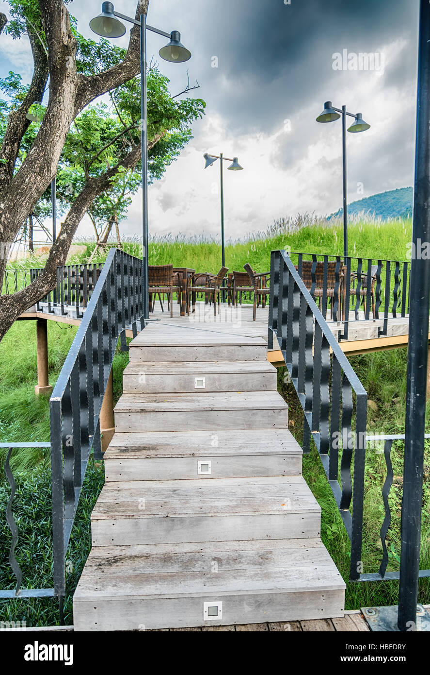 The wood table on natural outdoor of a restaurant with tree and cloudy
