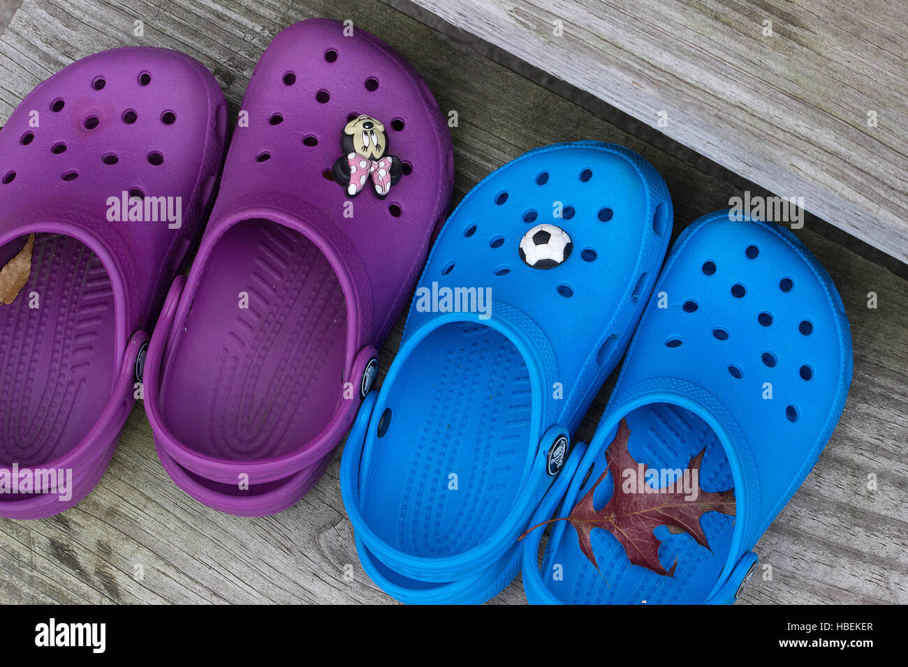 Kids Crocs- the popular children's casual outdoor sandals sit on the wood steps of a backyard stoop New York USA Fall season Stock Photo