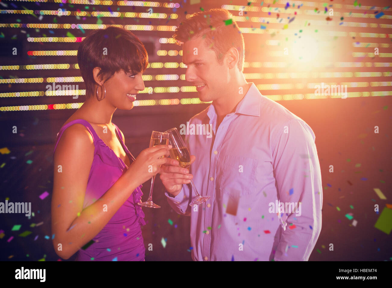 Composite image of couple toasting glass of champagne in bar Stock Photo