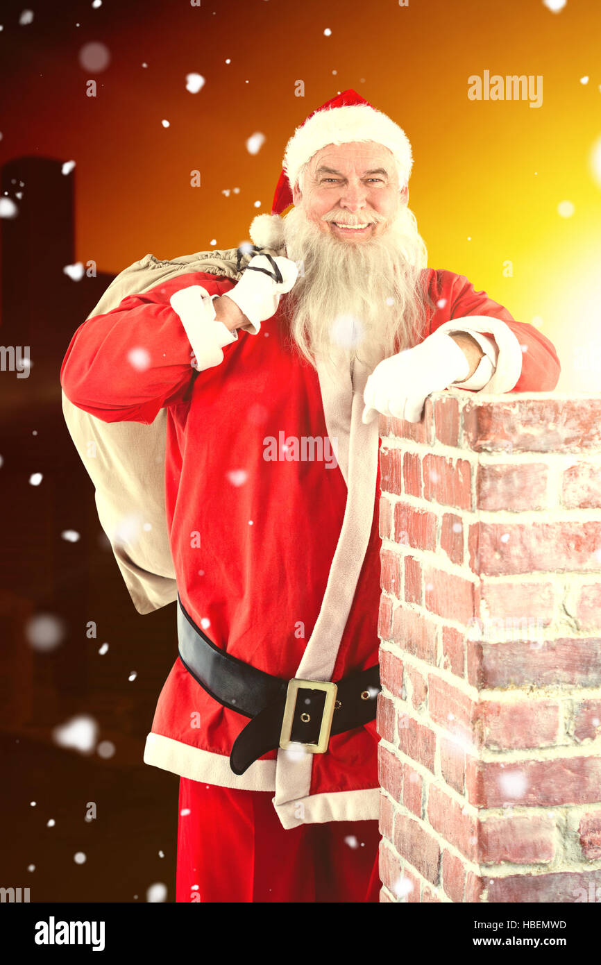 Composite image of portrait of santa claus carrying bag full of gifts Stock Photo