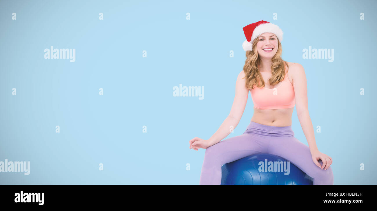 Composite image of smiling blonde woman sitting on exercise ball Stock Photo