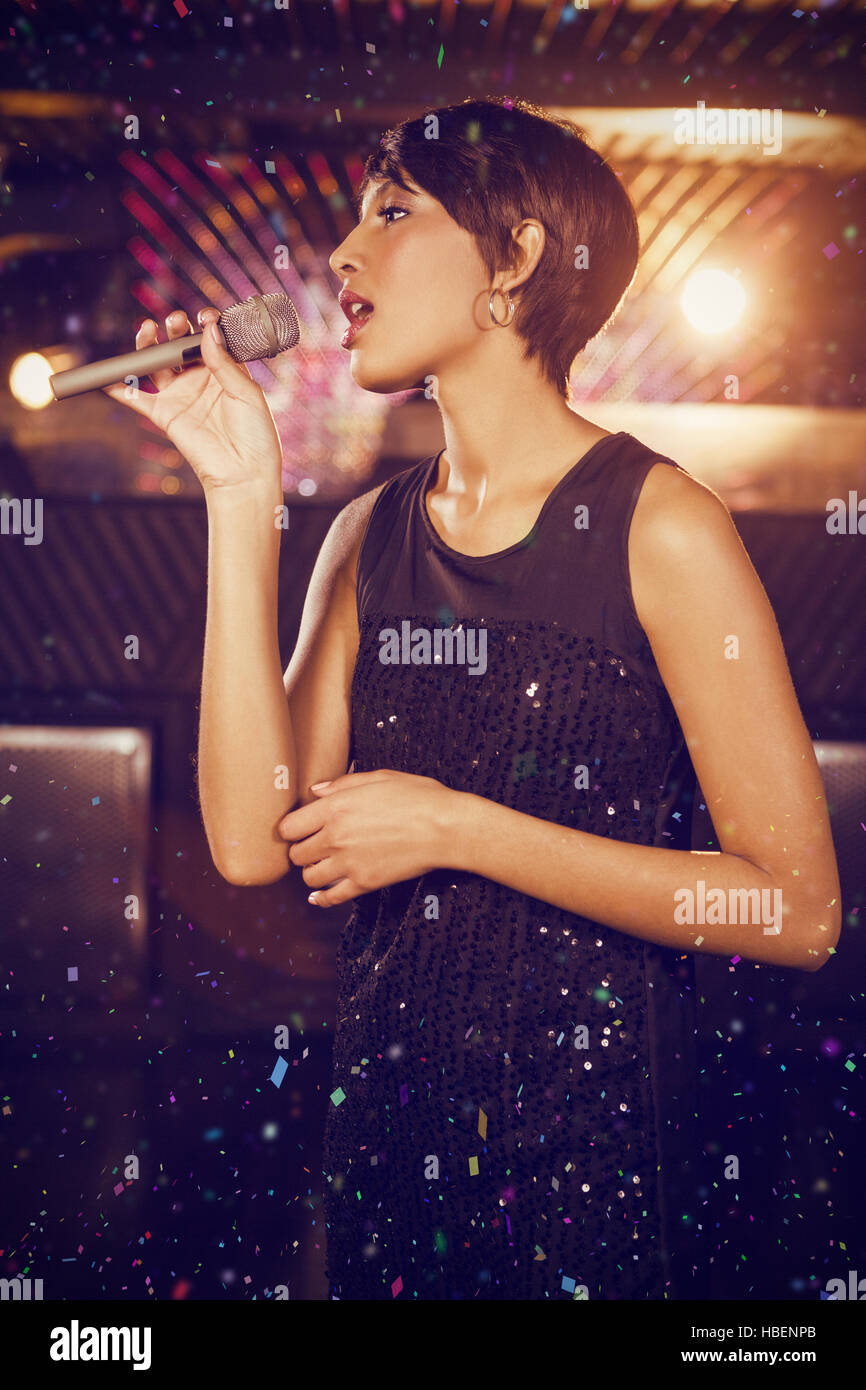 Composite image of woman singing in bar Stock Photo