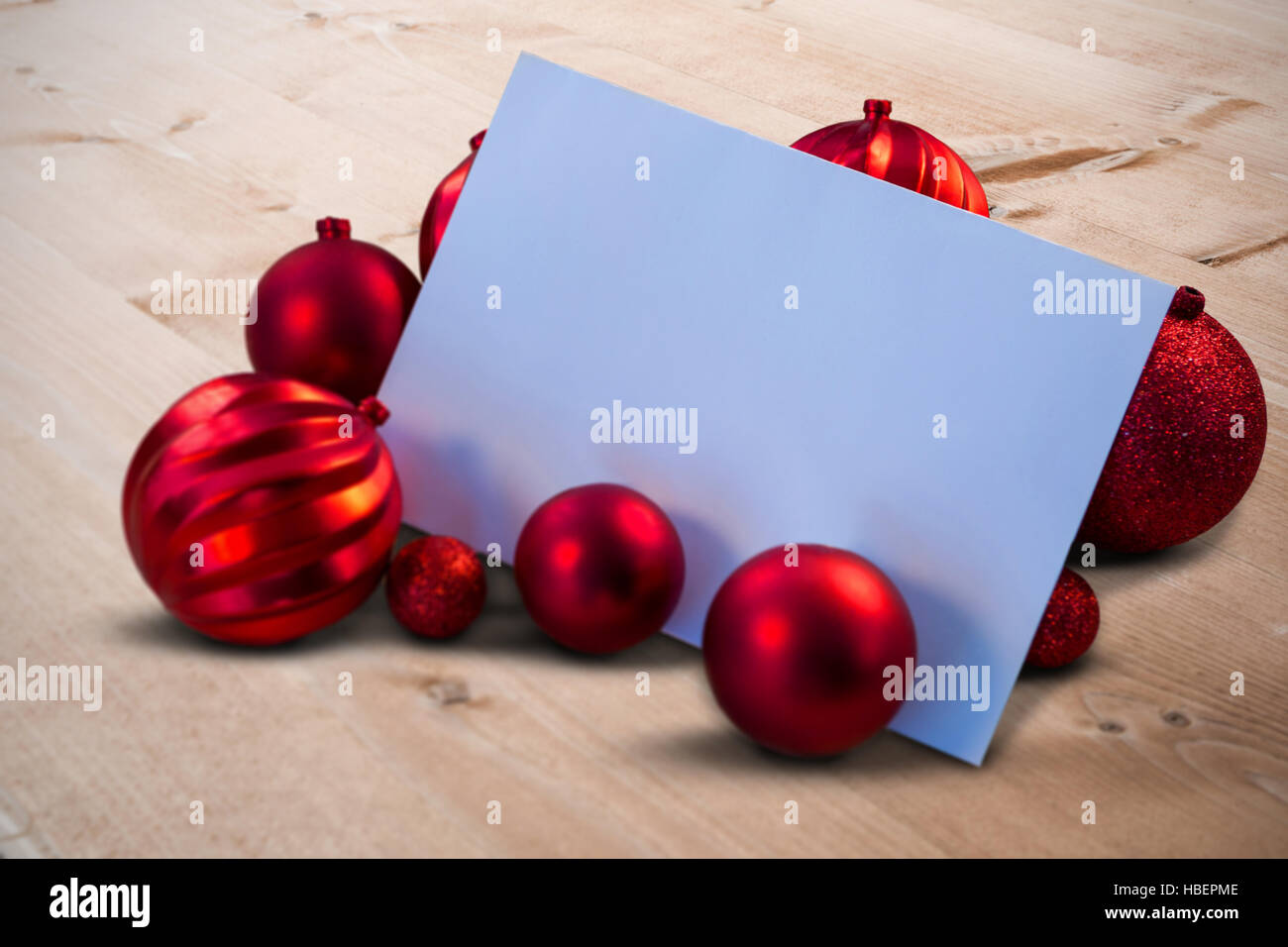 Composite image of red christmas baubles surrounding white page Stock Photo