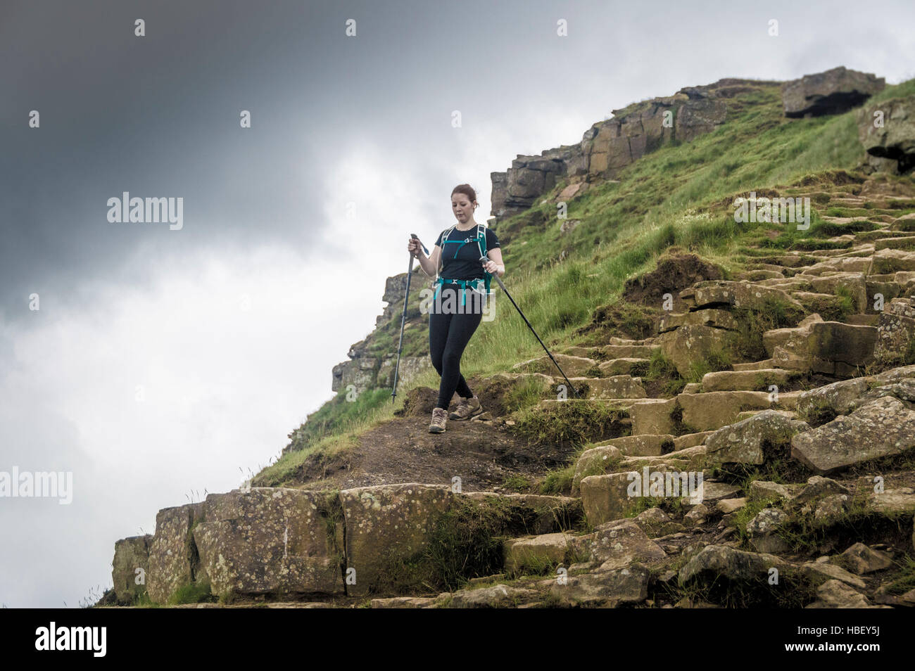Female on rocky hill path, Peak District, Derbyshire, UK. Stock Photo