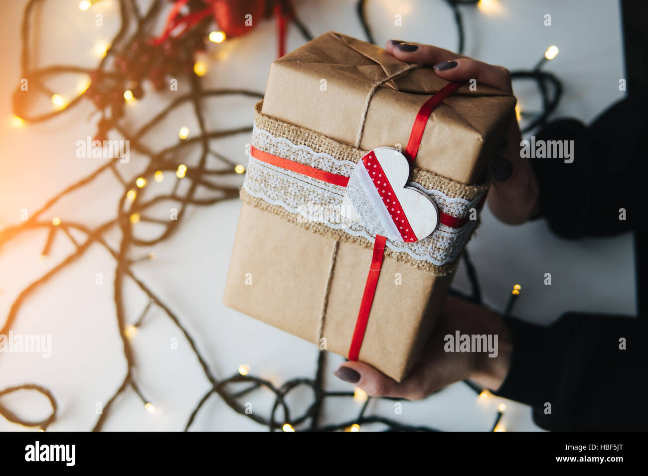 girl holding a Christmas gift in hand Stock Photo - Alamy