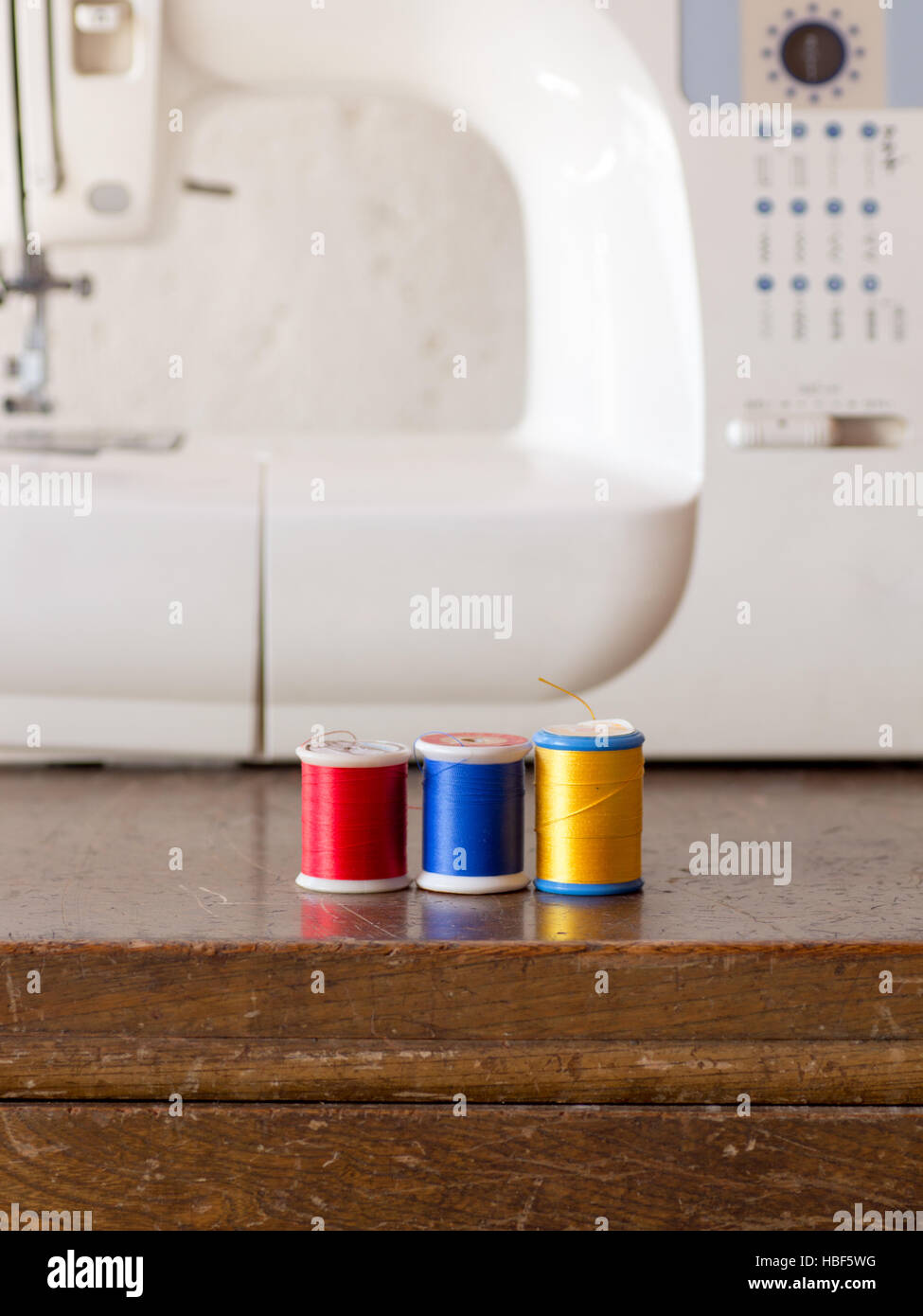 Sewing machine and its colorful threads on wooden table Stock Photo - Alamy