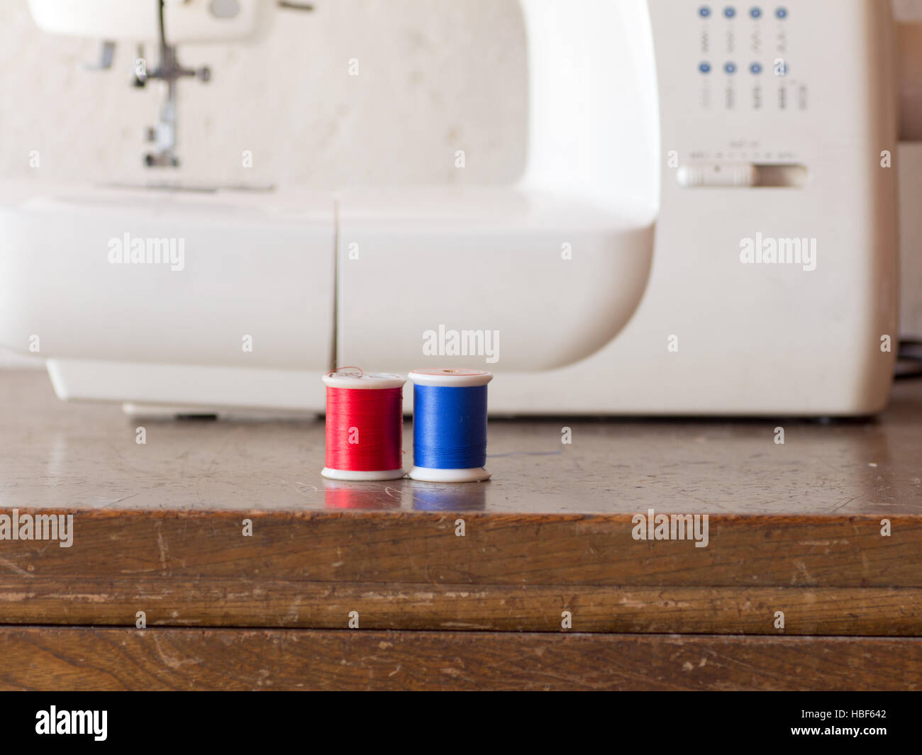 Sewing machine and its colorful threads on wooden table Stock Photo - Alamy