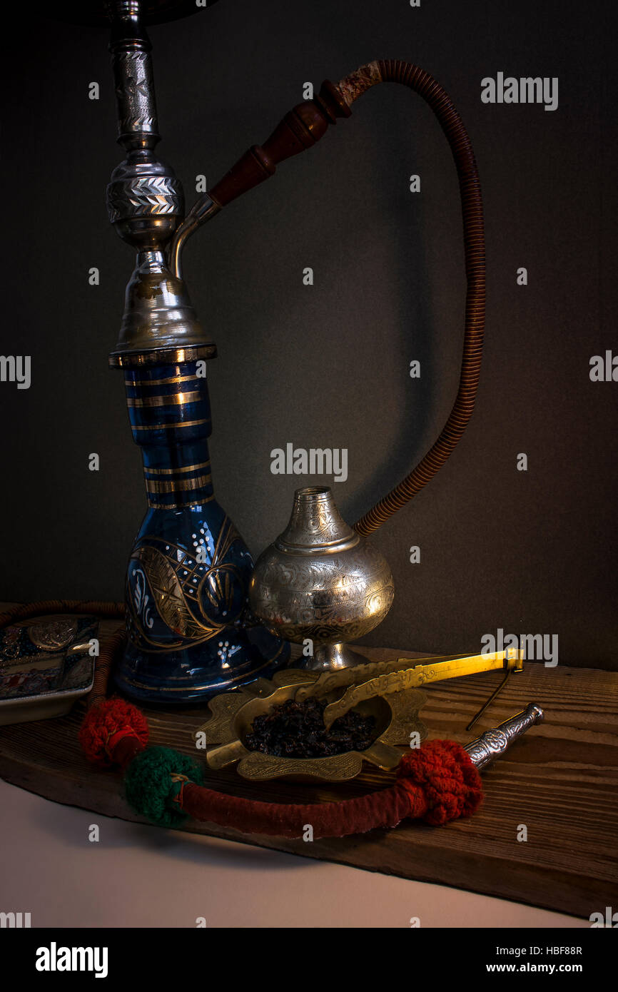 Still Life with Water Pipe. Nargile-Hookah with engraved equipment on dark environment Stock Photo