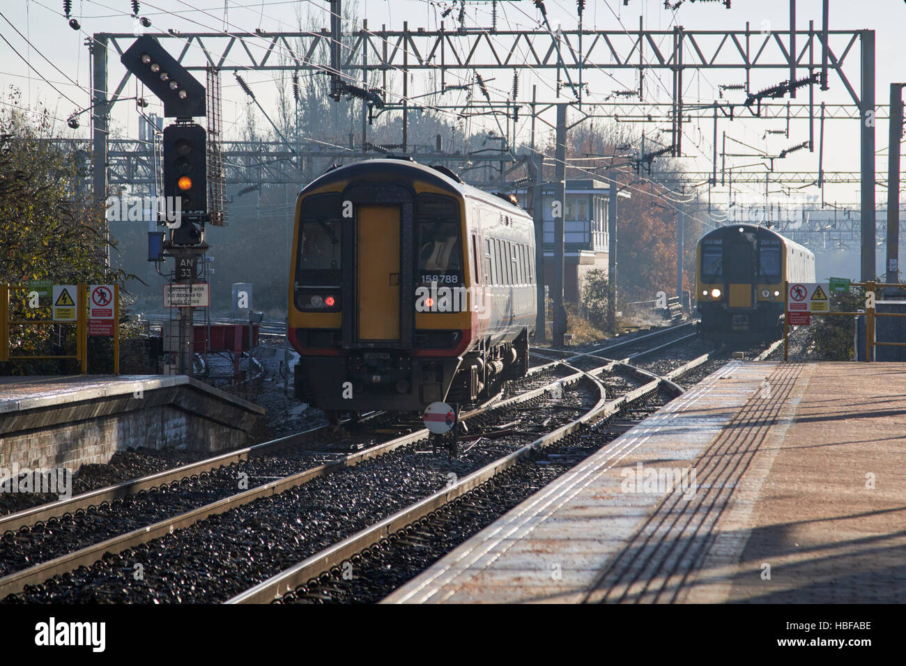 local trains passing on train line junction in a rail station in the uk Stock Photo