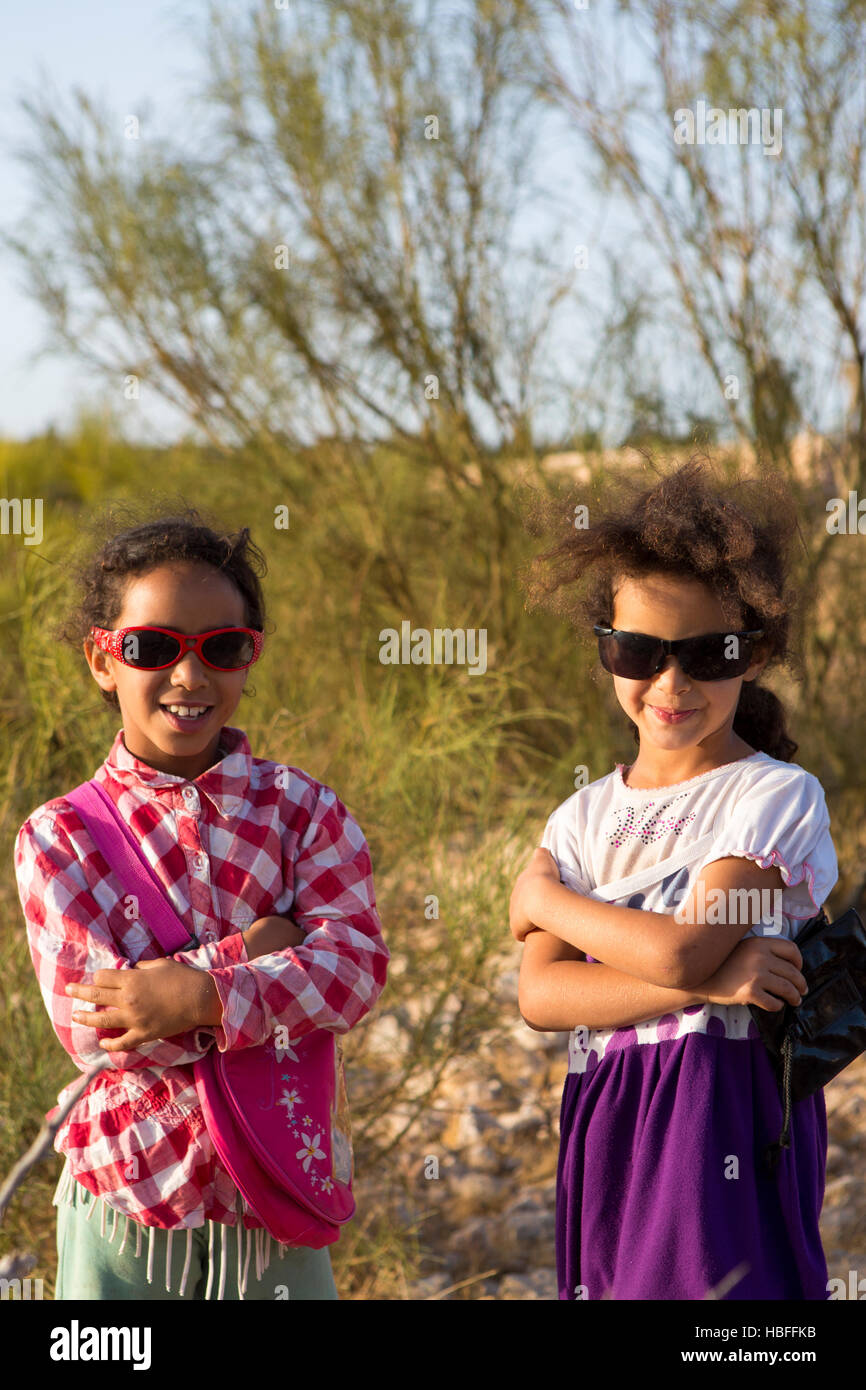 Two young Moroccan sisters posing with sunglasses and nature background Stock Photo