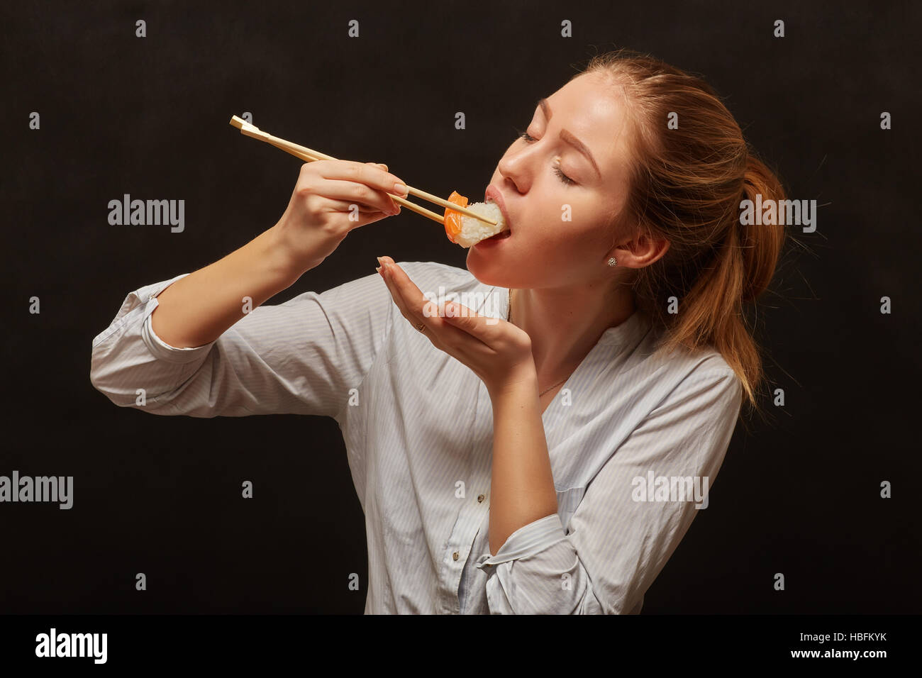 Девушка есть суши. Девушка ест роллы. Девушка ест палочками. Девушка ест. Девушка есть роллы палочками.
