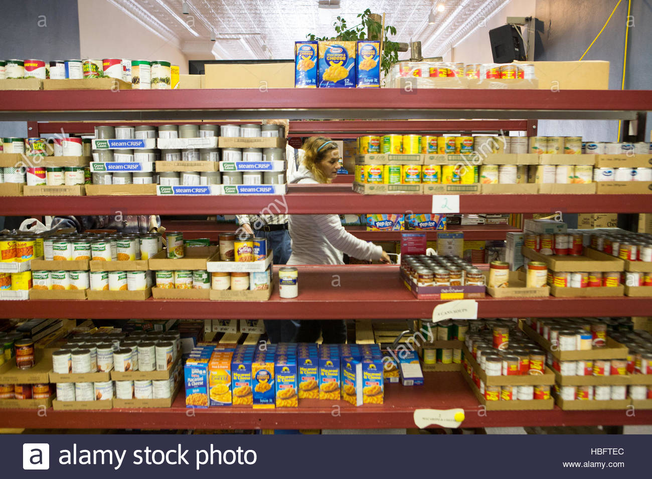 A Woman Chooses Food At The Jordan River Food Pantry Stock Photo