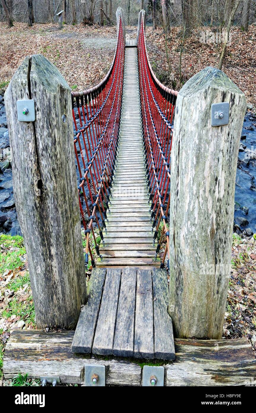 Suspension bridge over the creek Stock Photo