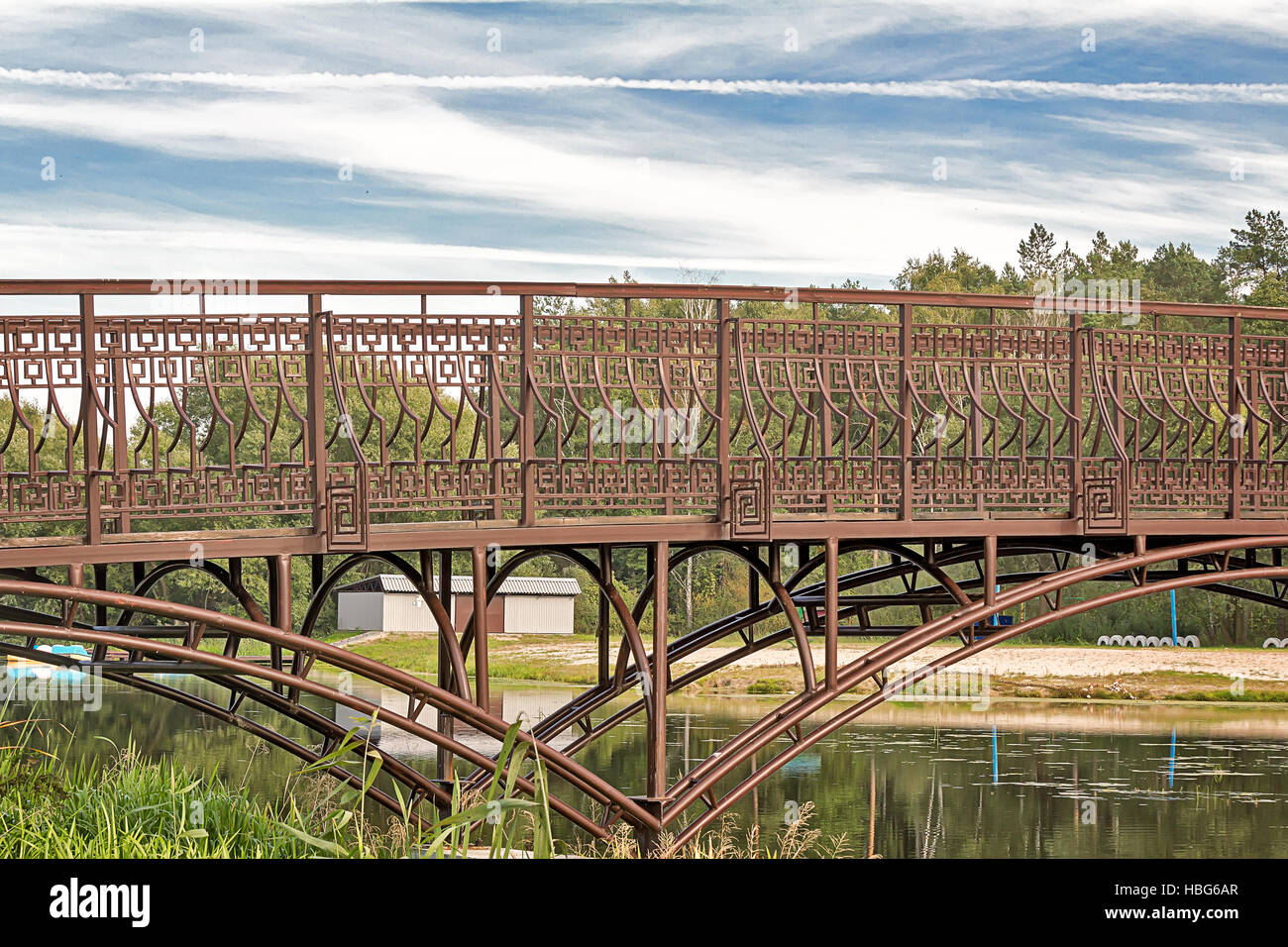 Metal bridge over a small river. Stock Photo