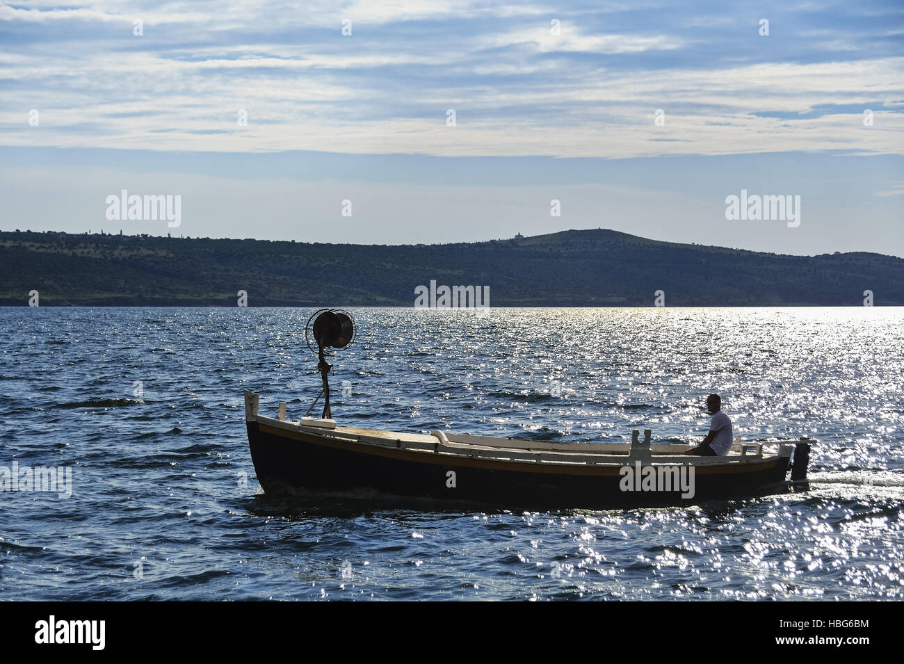 Fisherman in boat travels across the sea Stock Photo